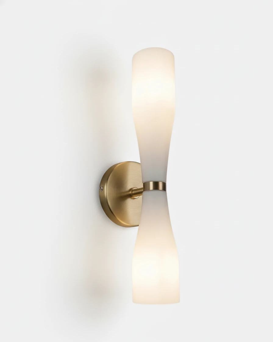 Brass wall sconce DALIA No.02 in Warm Gold, white hourglass glass diffuser glowing on a round brass backplate