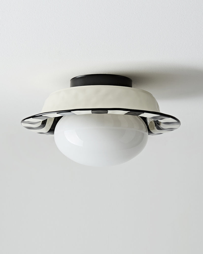 Ceramic flush mount ceiling light OLEA No.02 from an angle, black cap and white corolla with the globe off