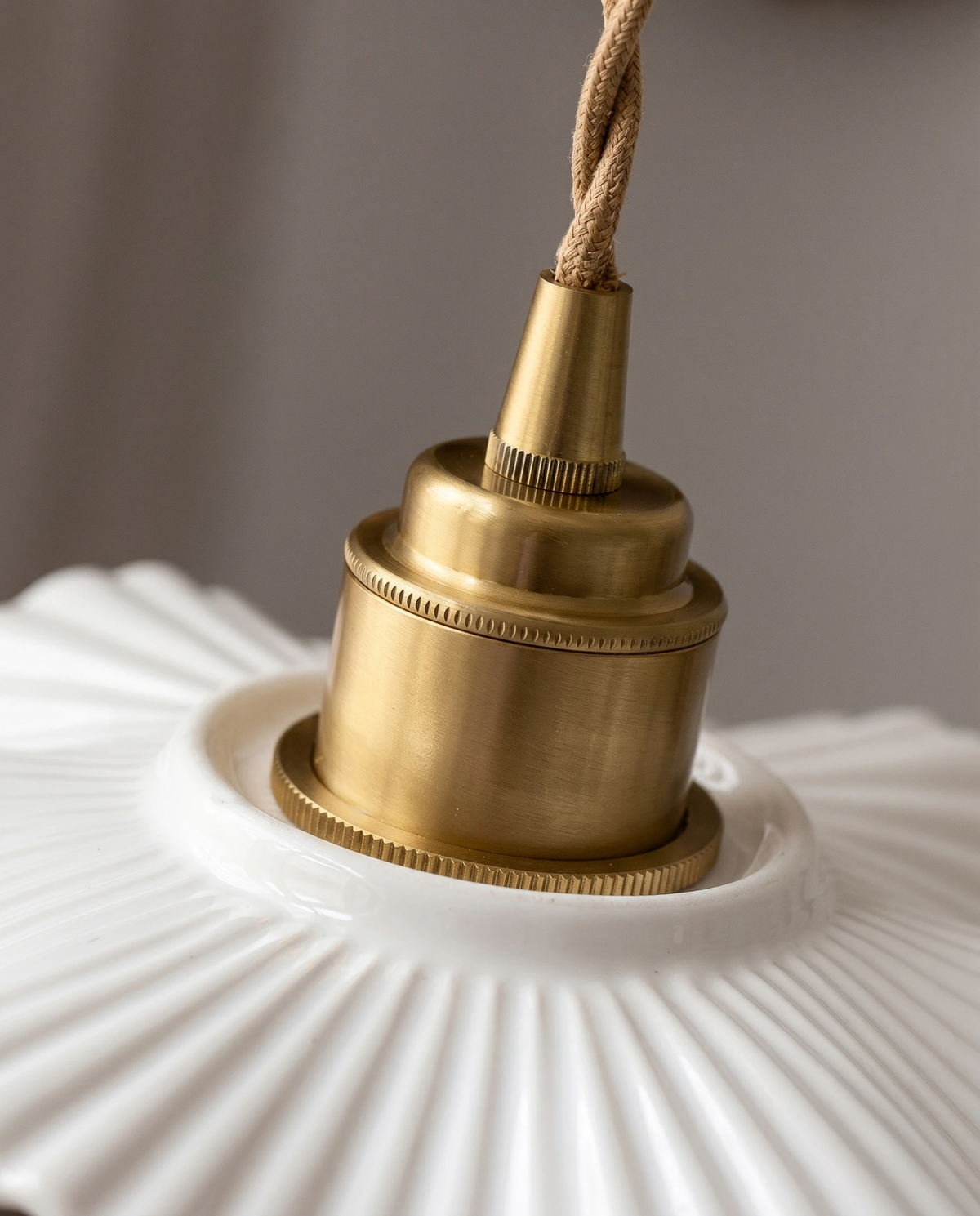 Close-up of the ribbed copper socket seated on the pleated ceramic shade of the ALBA No.01 ceramic pendant light