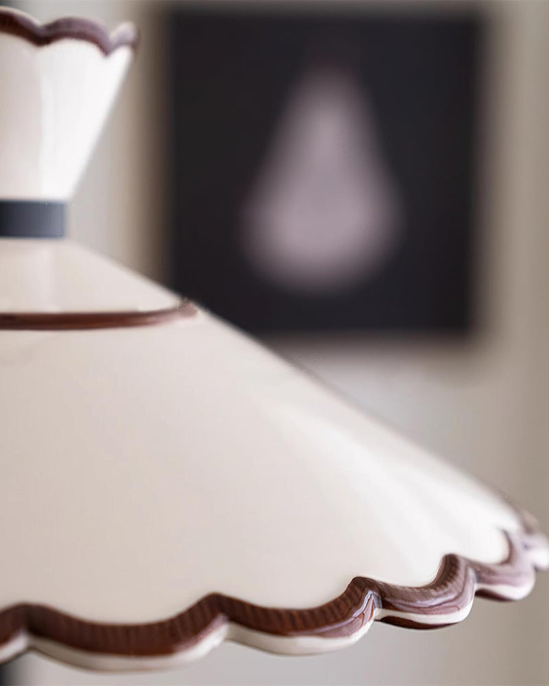 Close-up of the cream white shade rim with brown trim on the ceramic pendant light MELI No.04