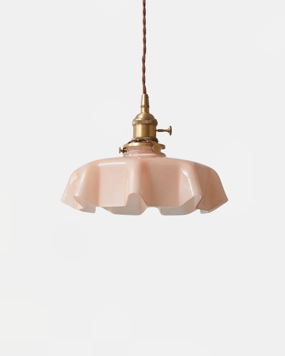 Ceramic pendant light CORA No.01 in dusty rose, fluted scalloped shade hanging from a brass socket
