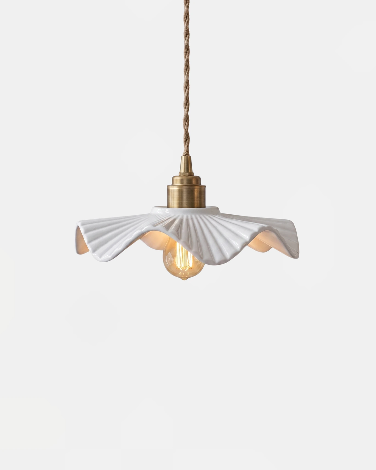 Ceramic pendant light ALBA No.01, wavy white ceramic petal shade on a copper socket and twisted cord, bulb lit