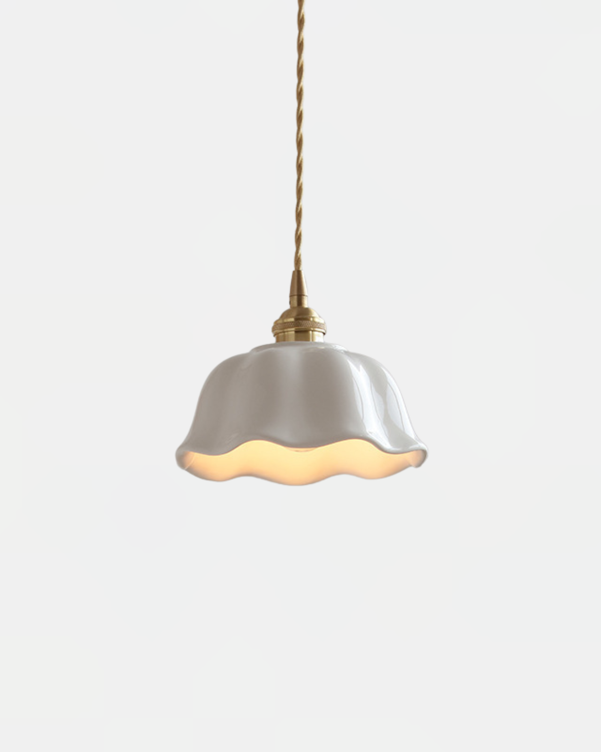 Ceramic pendant light MELI No.03, glazed cream ceramic bell with a wavy rim, brass fitting and twisted cord, lit