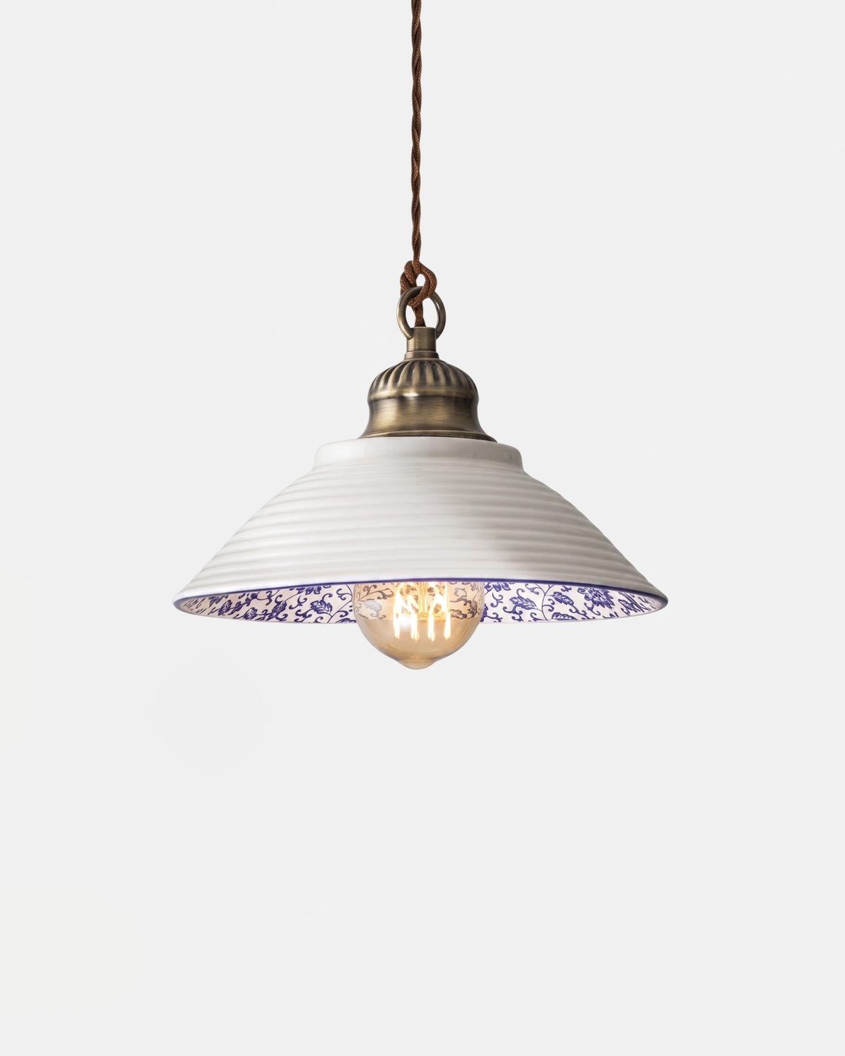 Ceramic pendant light MELI No.01 in the Sillage sculpted dome shape, ribbed white shade with a blue floral rim, lit