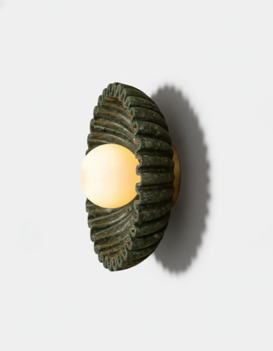 Ceramic wall sconce RAGGI No.01 in green, side view of the ribbed sunburst with the opal globe switched on