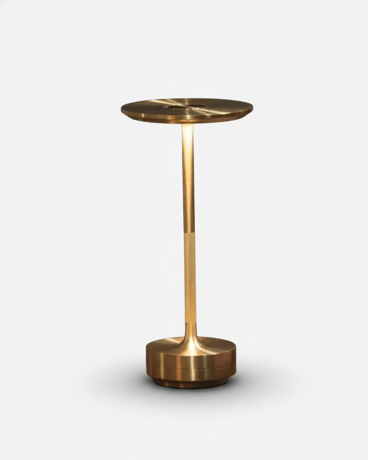 Cordless desk lamp LUMA No.05 in brass, disc top lit over a slim stem and weighted round base