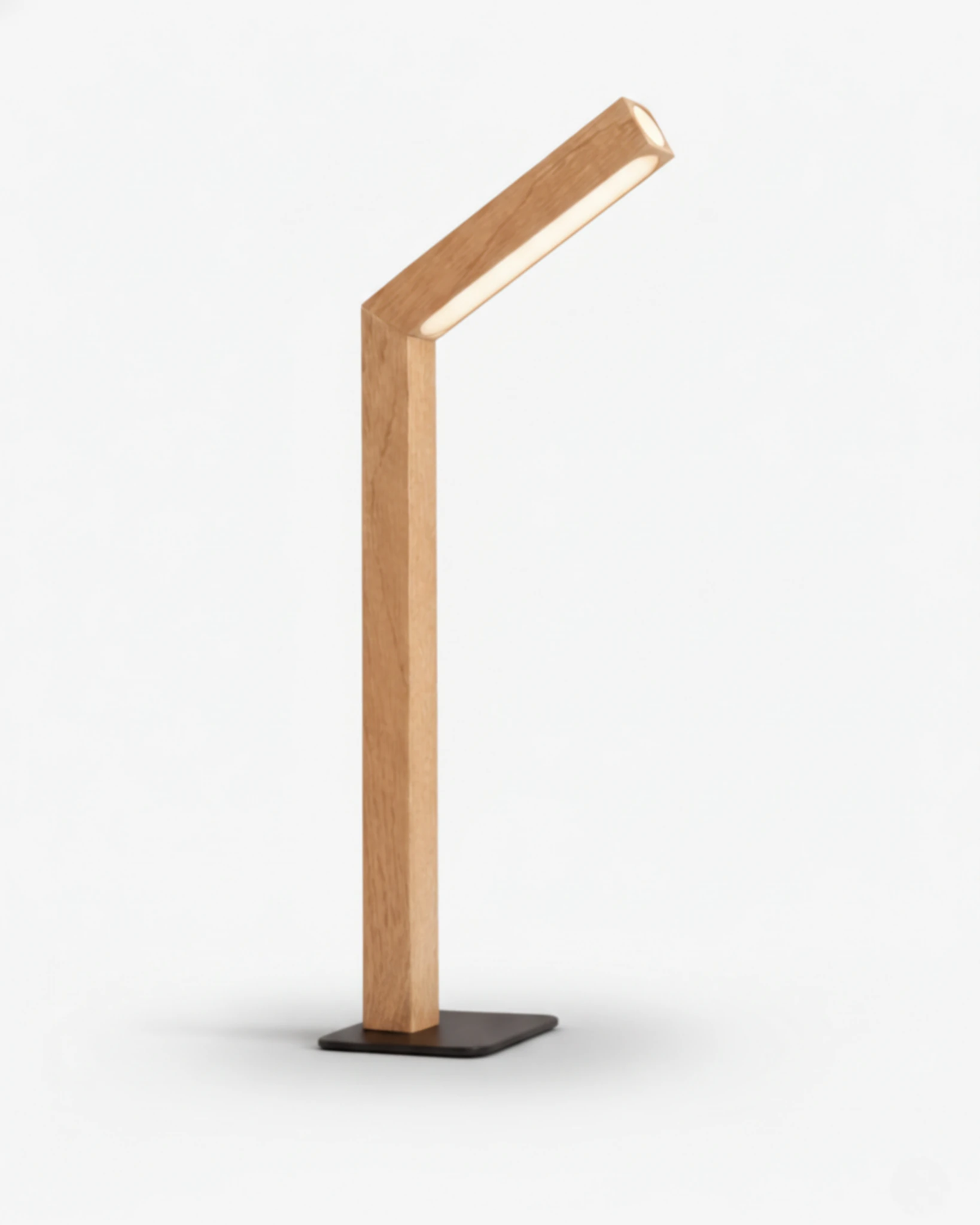 Cordless desk lamp RAMO No.01 in light beech, bent wood arm on a black base with the light on