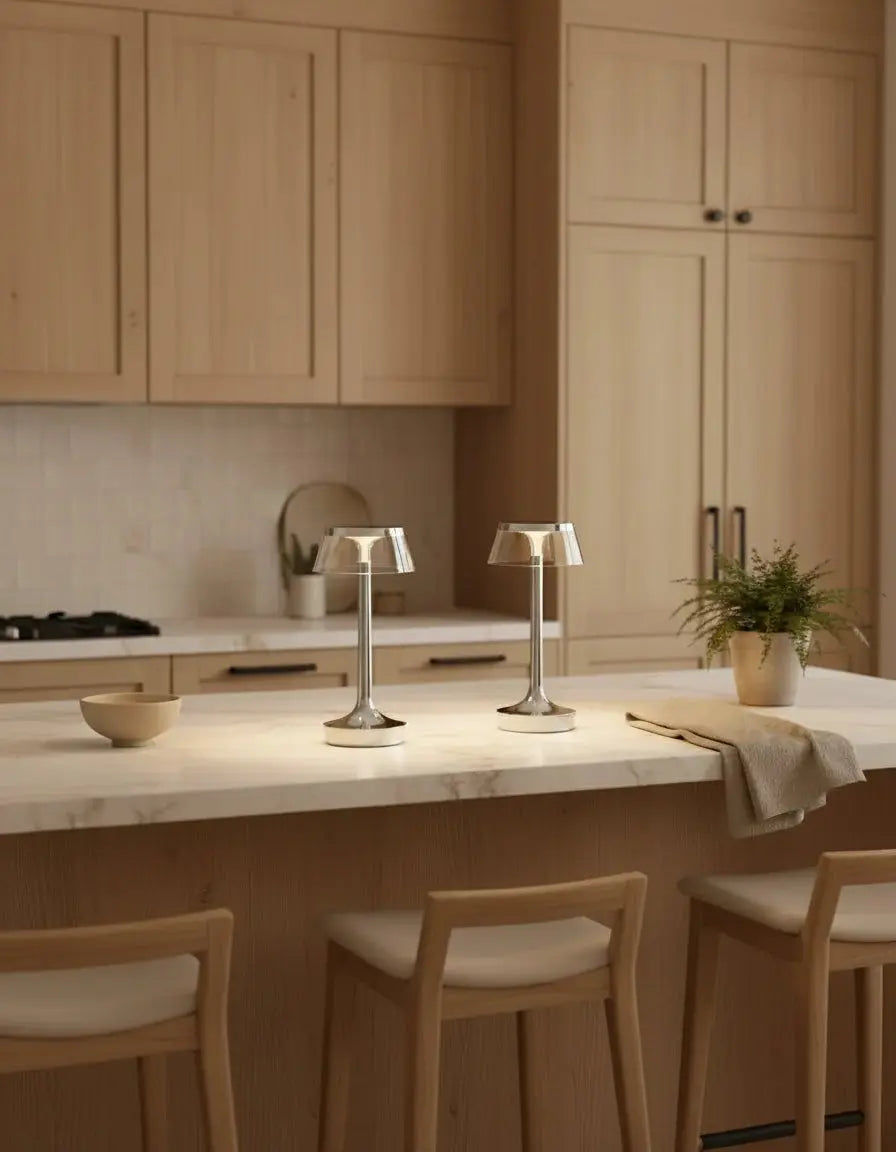 Two cordless table lamps ZARA No.01 in chrome lit on a kitchen island counter with wooden stools