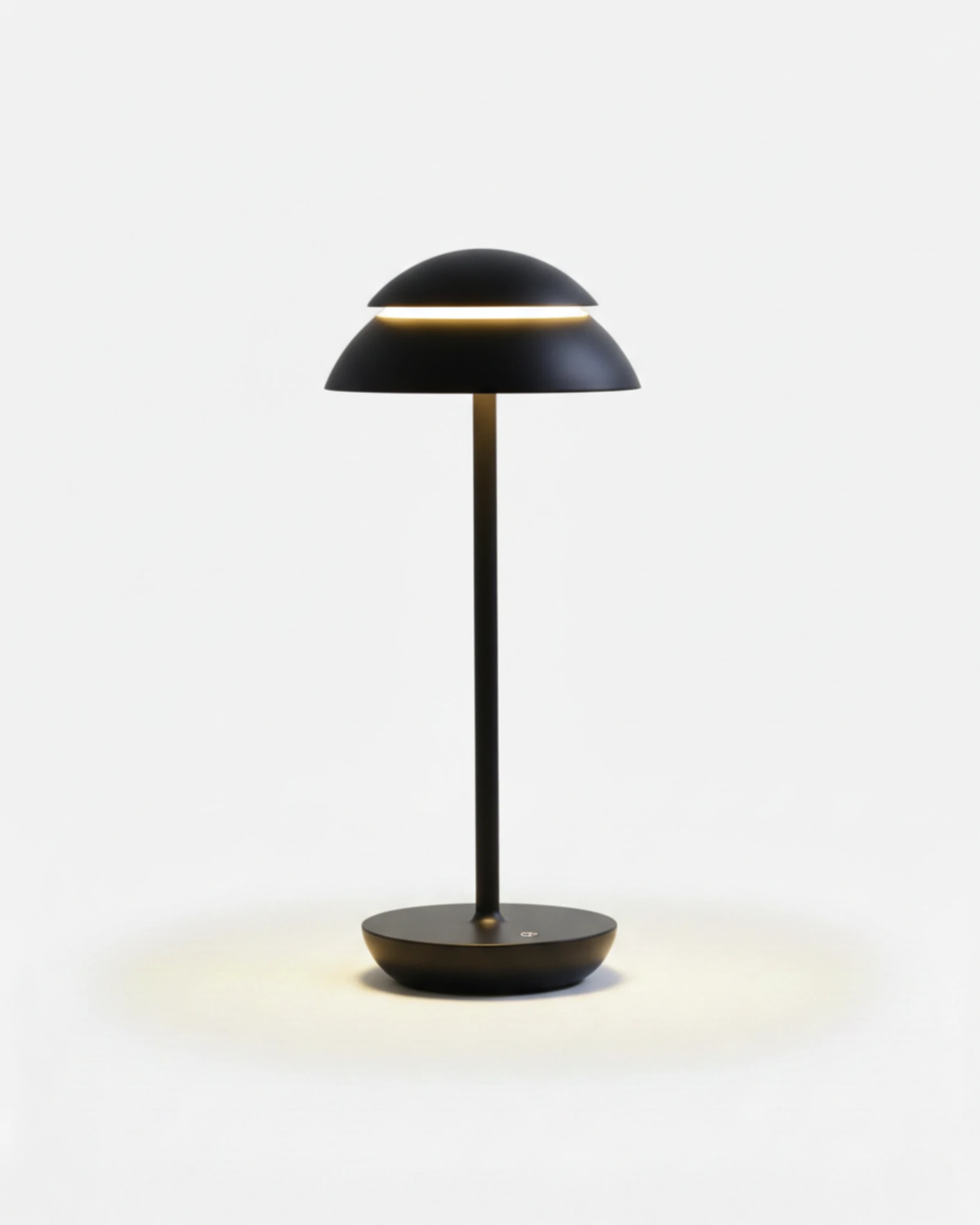 Cordless table lamp CALMA No.01 in Gloss Black, smooth black dome lamp lit with a warm light ring