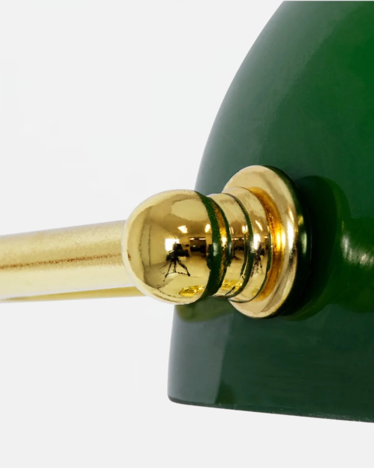 Close-up of the brass pivot joint beneath the green glass shade of the BANCO No.01 glass desk lamp