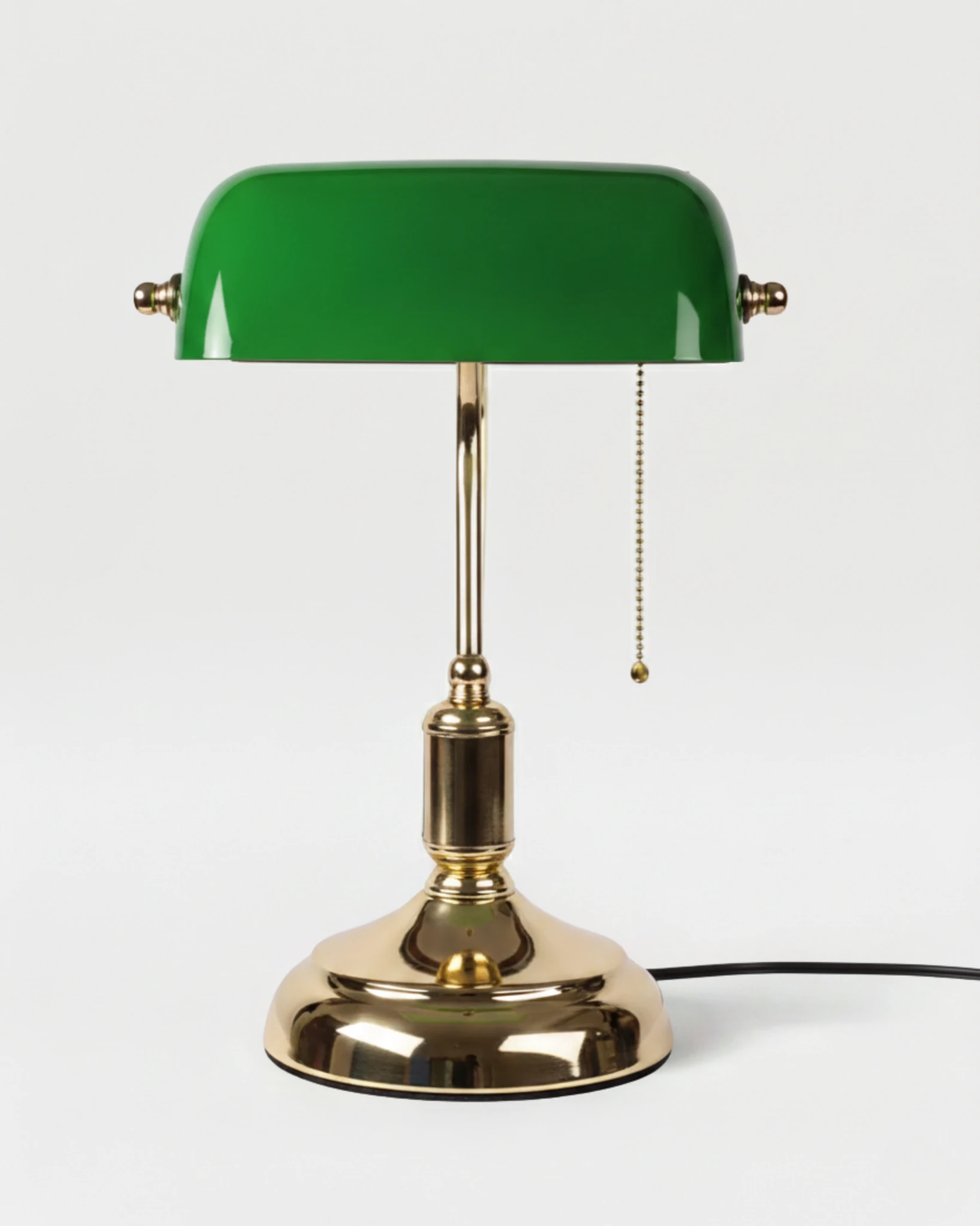 Glass desk lamp BANCO No.01 in Emerald Green, green glass shade with brass pull chain on a polished brass base, unlit
