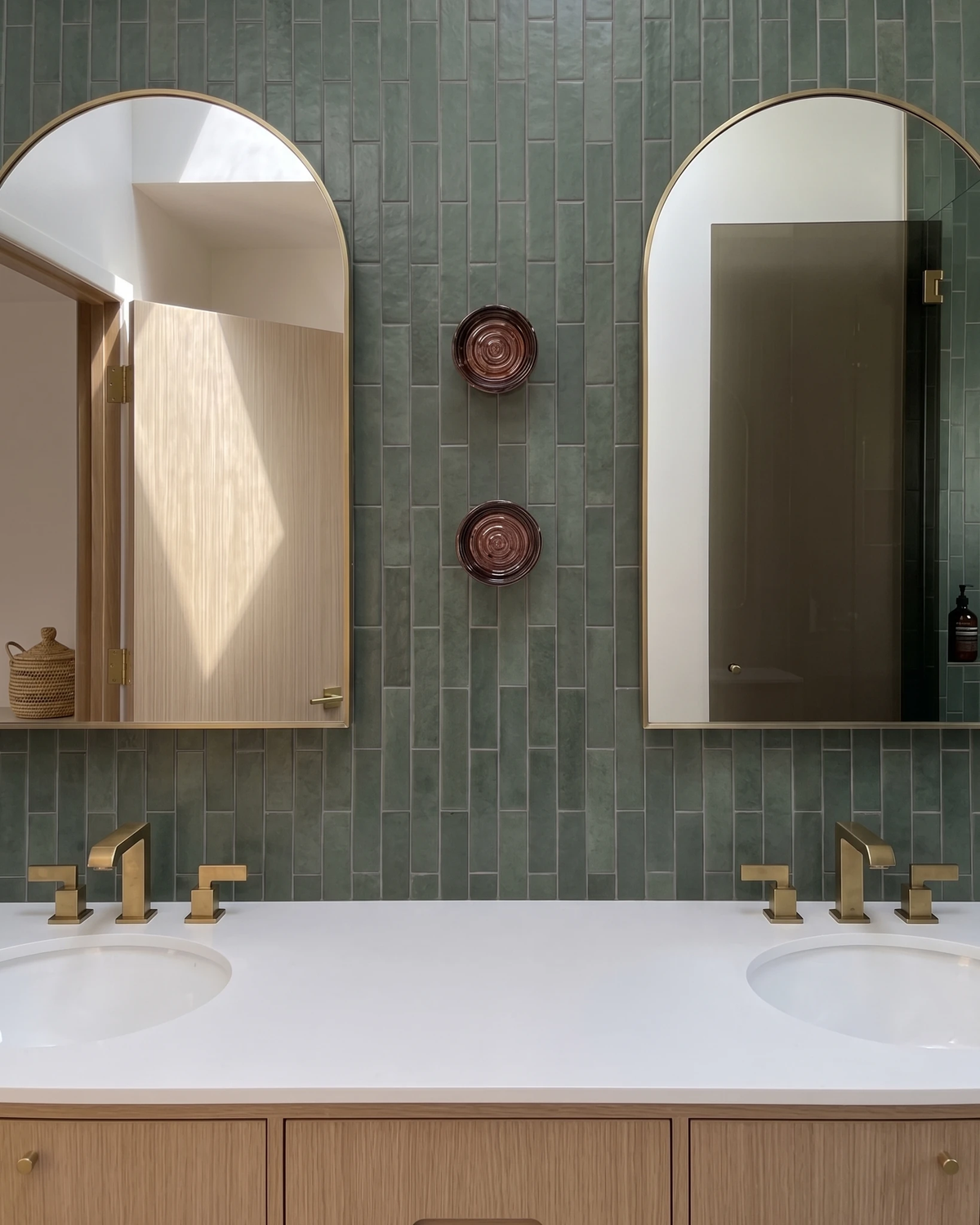 Glass wall sconce HALO No.08, two amber units between arched mirrors over a double sink bathroom vanity