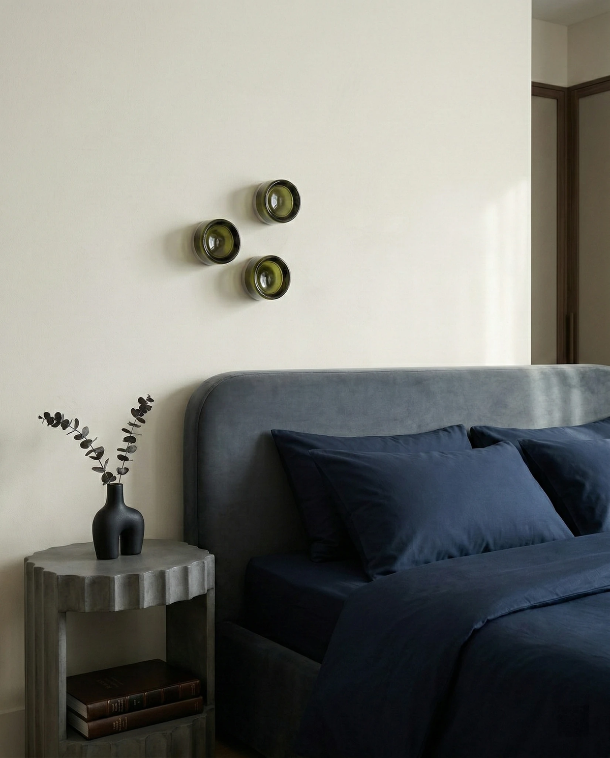 Glass wall sconce HALO No.08, cluster of three forest green units above a gray upholstered headboard