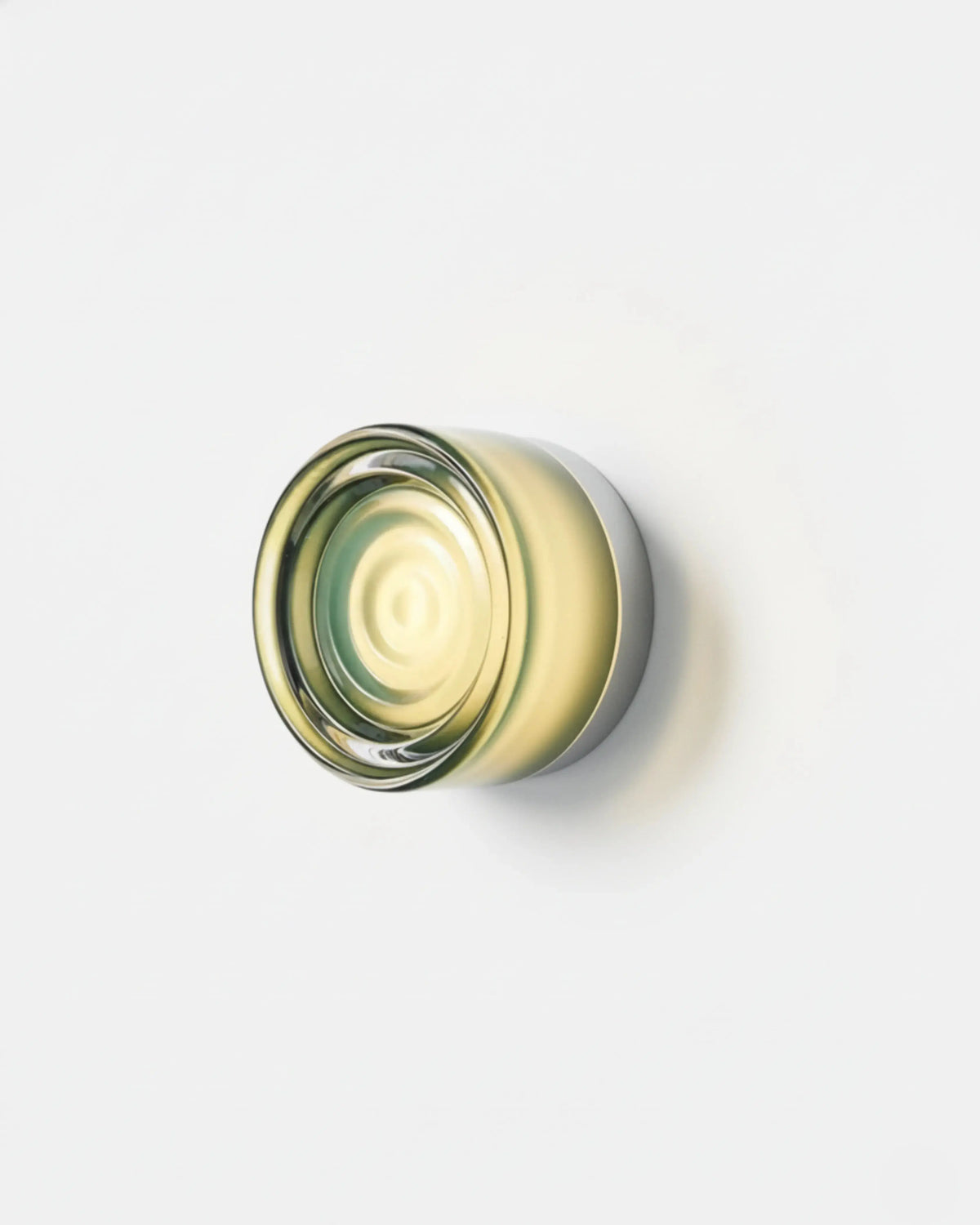 Glass wall sconce HALO No.08 in Jade, pale green rippled glass disc mounted on a white wall