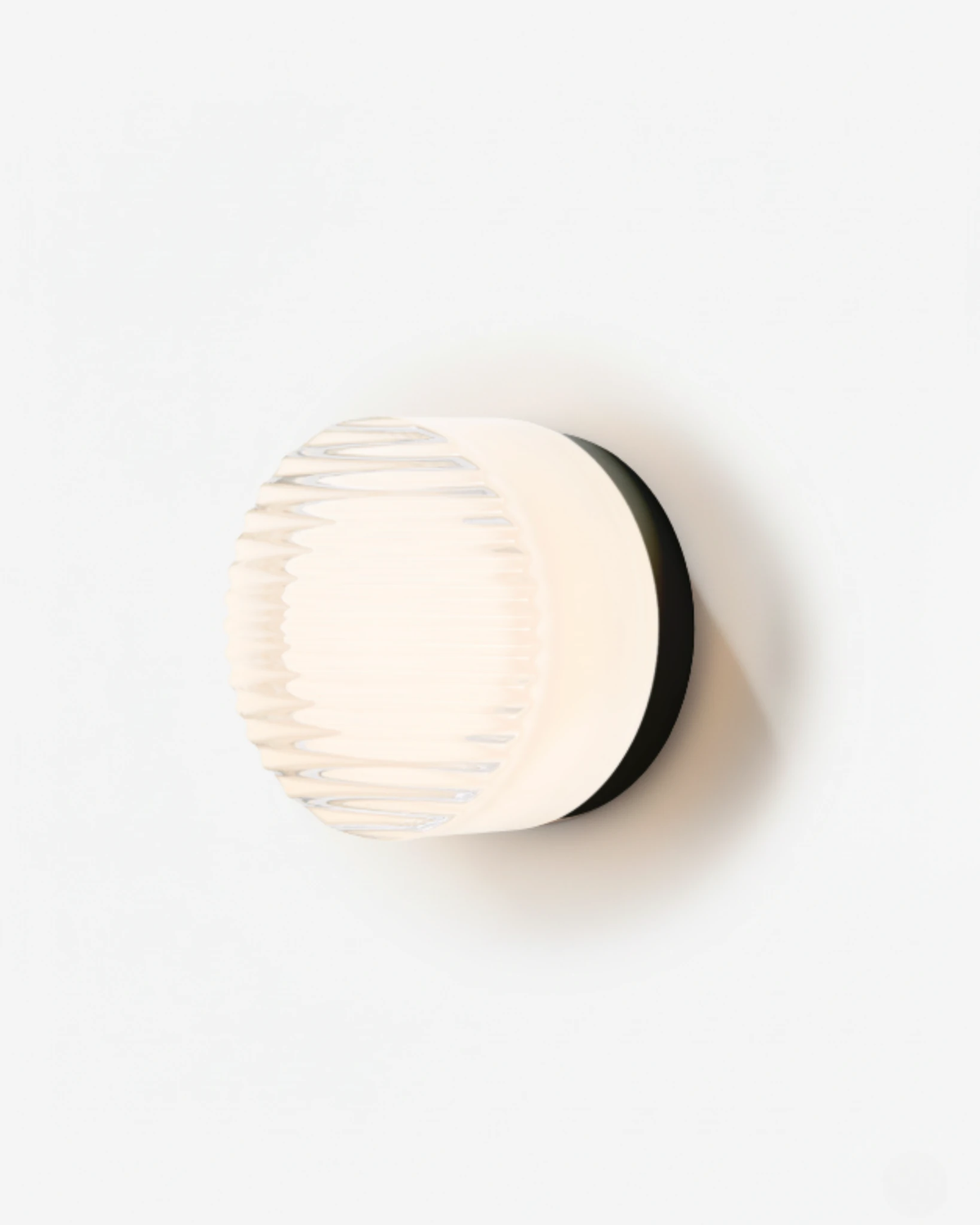 Glass wall sconce HALO No.08 in Opal Fluted, ribbed white glass on a black base, switched on