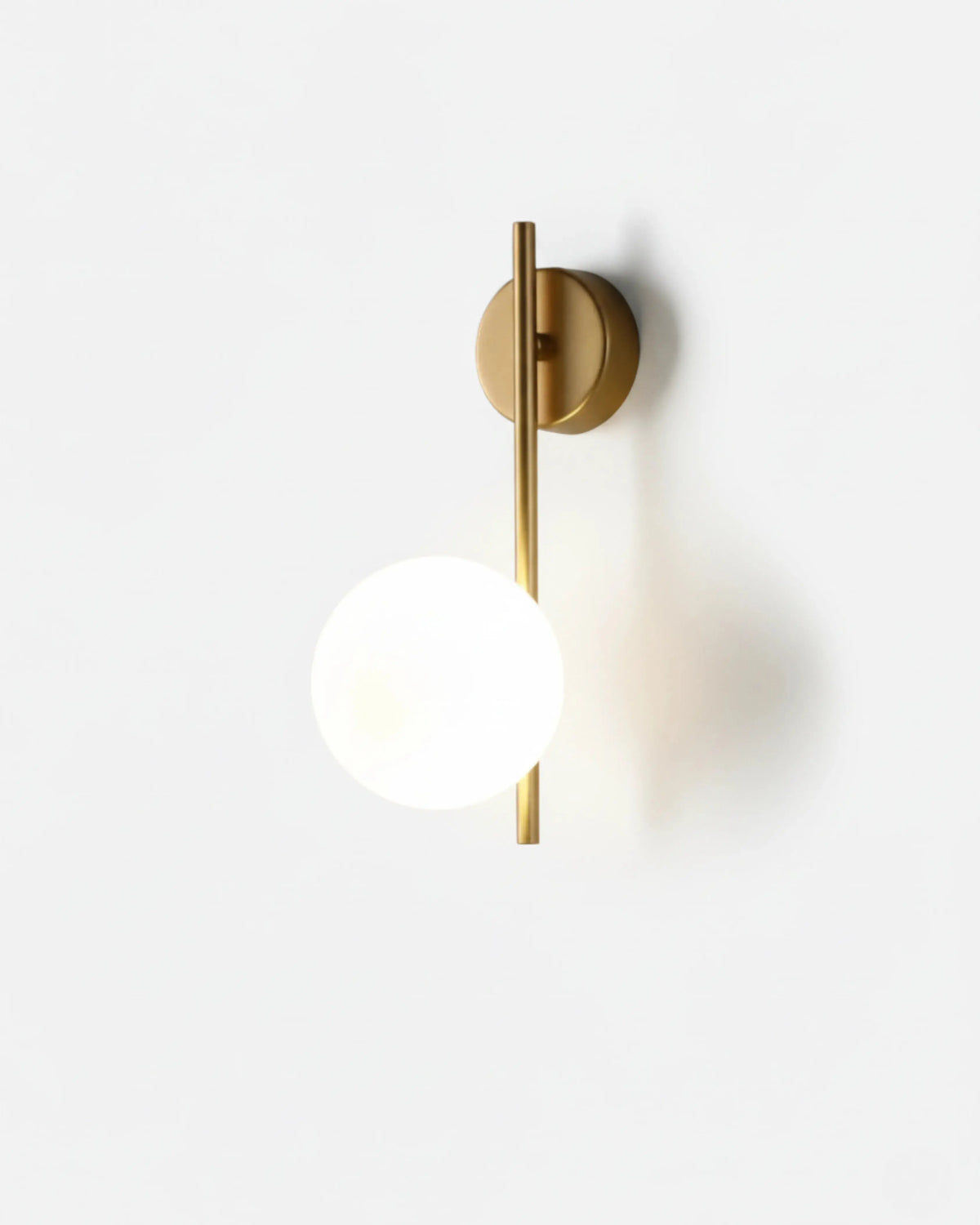 Globe wall sconce ASTRO No.01 in brushed brass, opal glass globe offset on a vertical brass bar