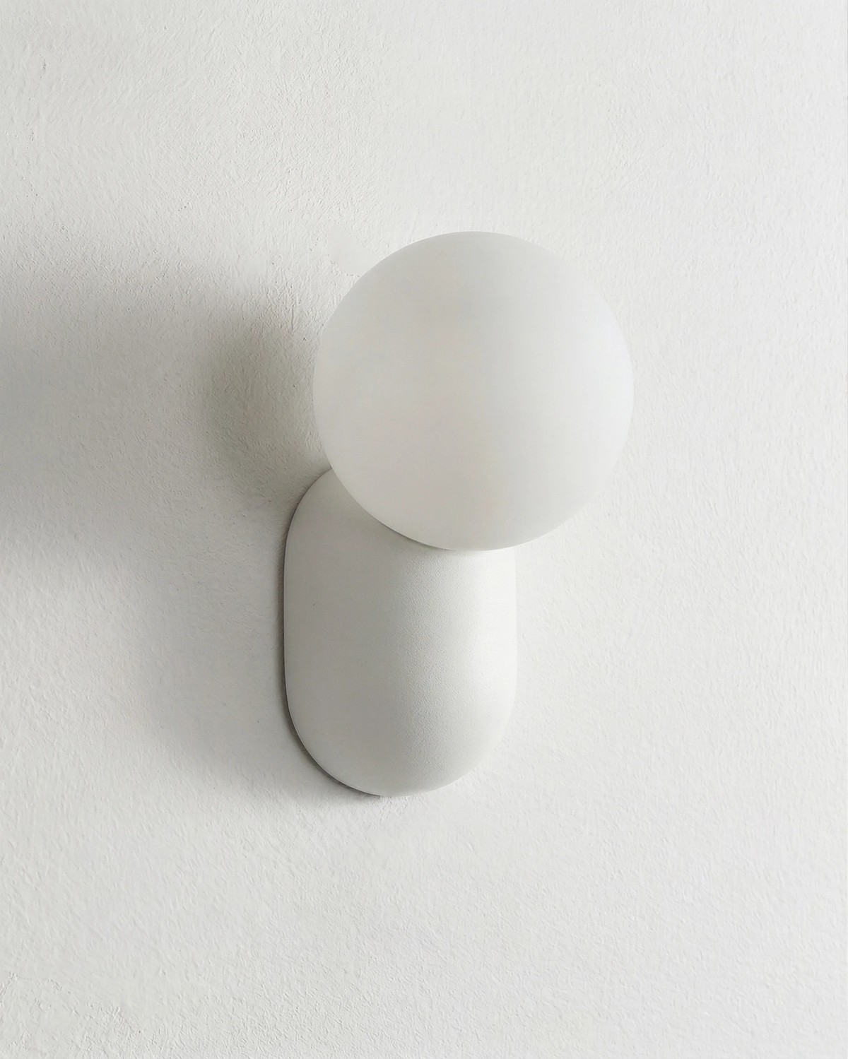 Globe wall sconce AURA No.04 in Cream White, matte white globe and capsule on a white wall, switched off