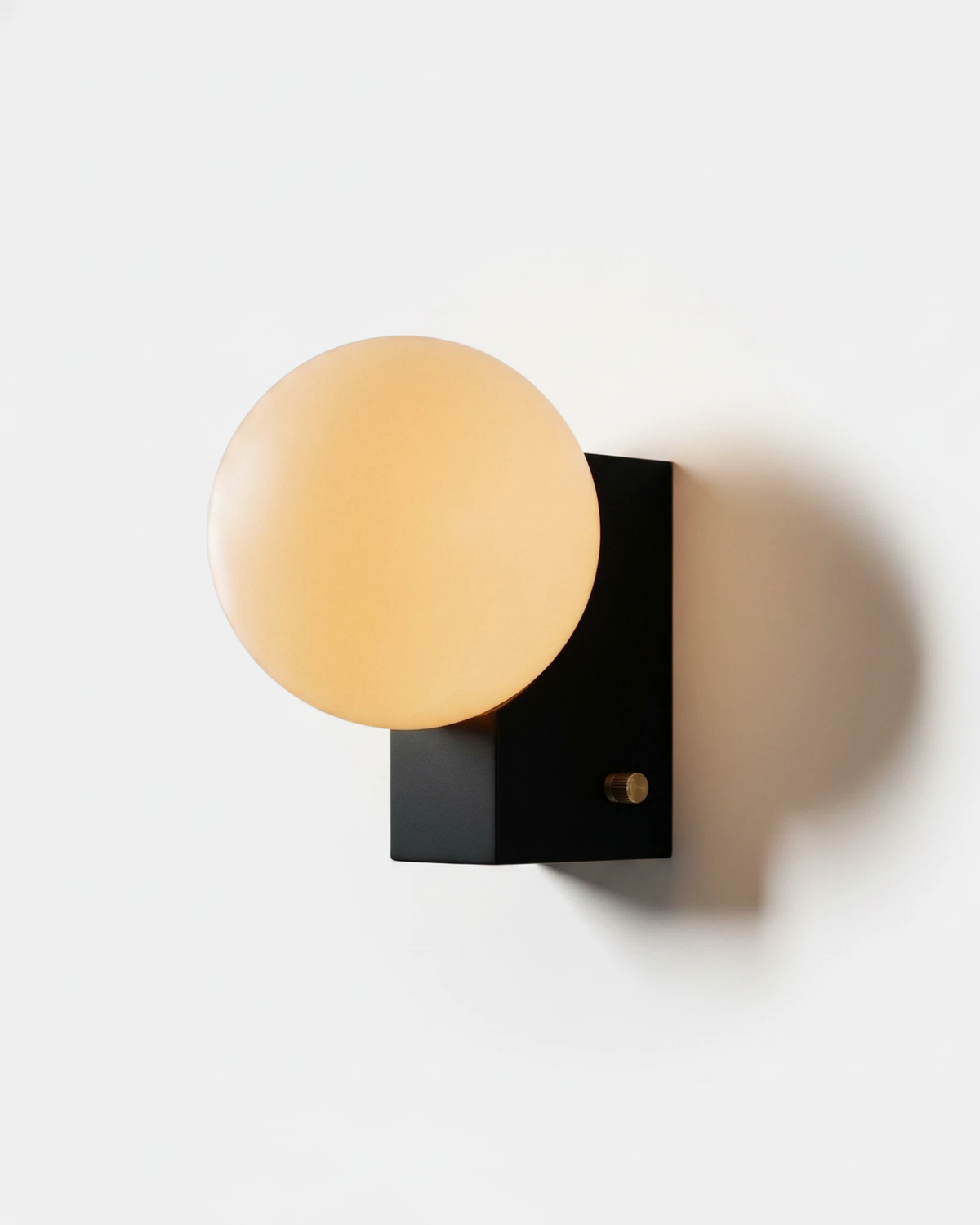 Globe wall sconce ELBA No.01 in deep black, opal globe on a compact black block with a side switch