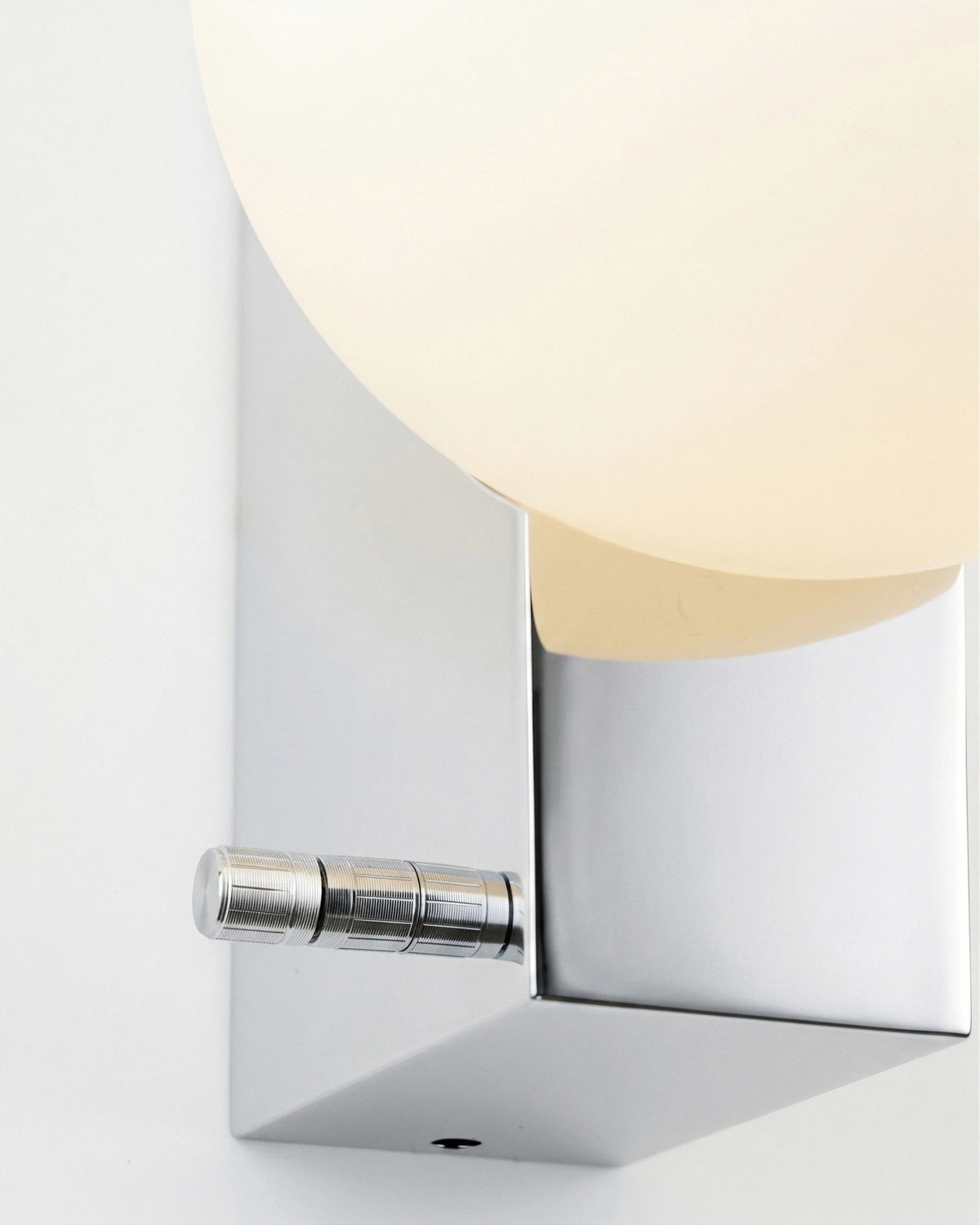 Close-up of the chrome block, switch and opal globe of the globe wall sconce ELBA No.01