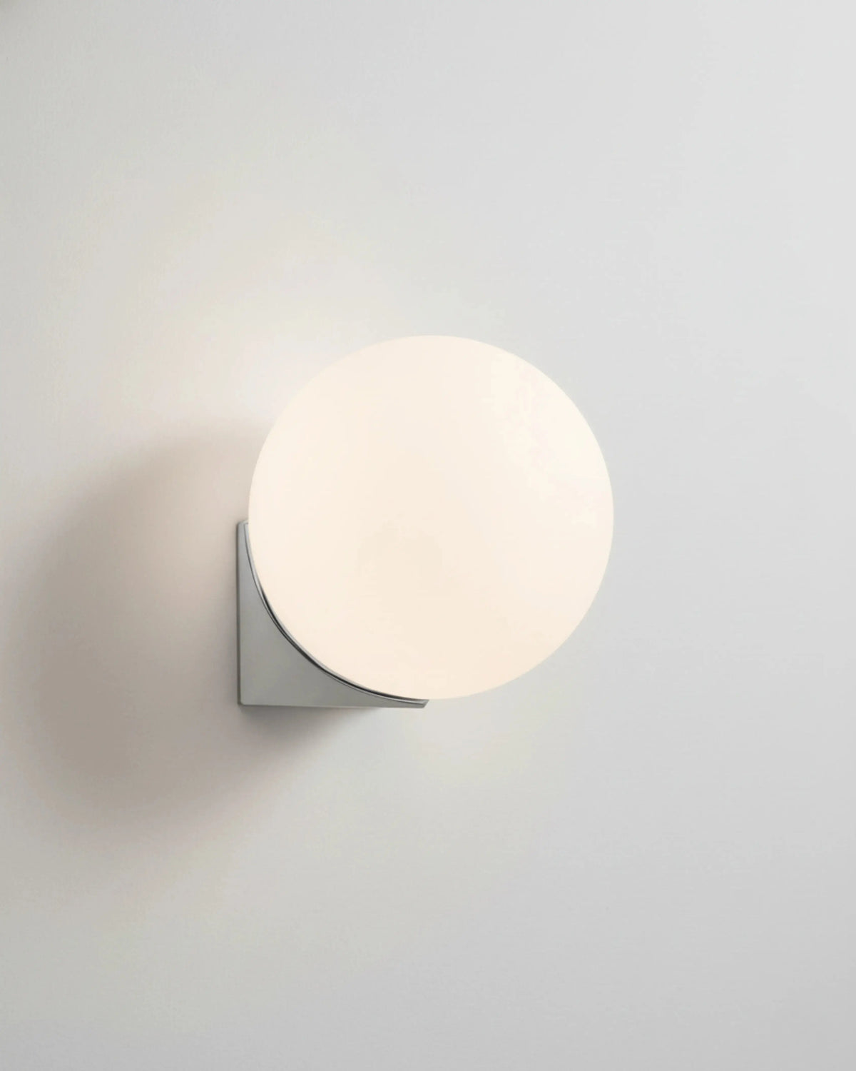 Globe wall sconce AURA No.03 single, mini opal globe lit on a polished silver bracket, white background