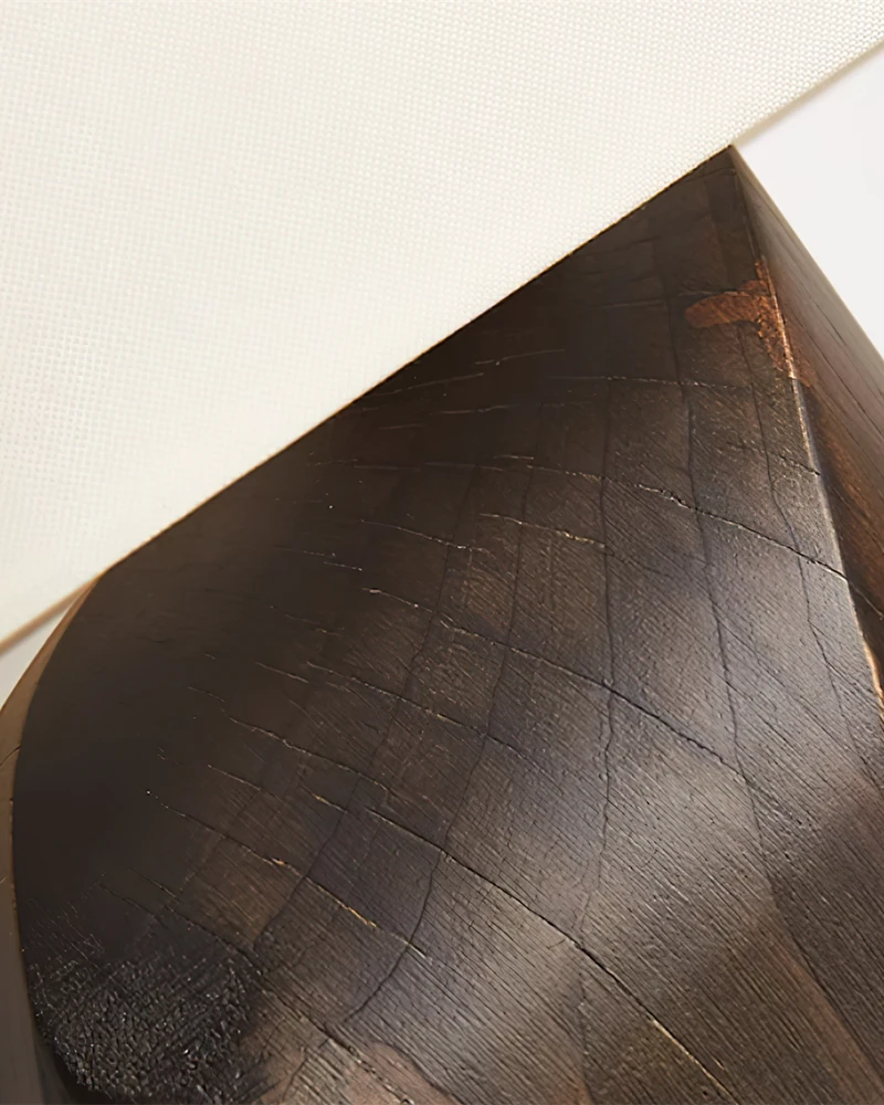 Close-up of the sculpted dark walnut grain on the base of the linen shade table lamp ROCCA No.02