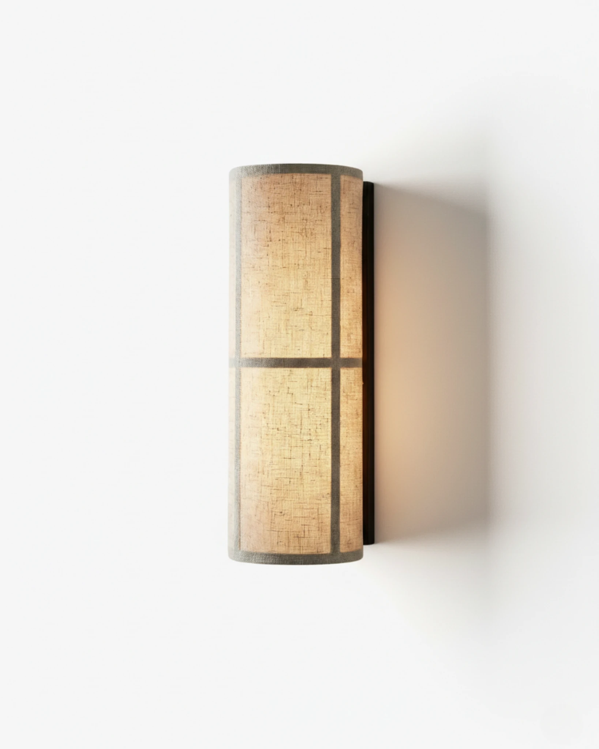 Linen shade wall sconce FUMO No.01, tall natural linen cylinder glowing inside a black iron frame