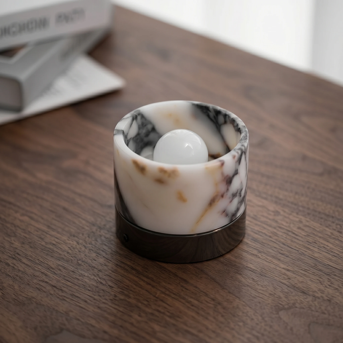 Marble flush mount ceiling light NERA No.06 standing unlit on a walnut table, frosted bulb visible inside the marble