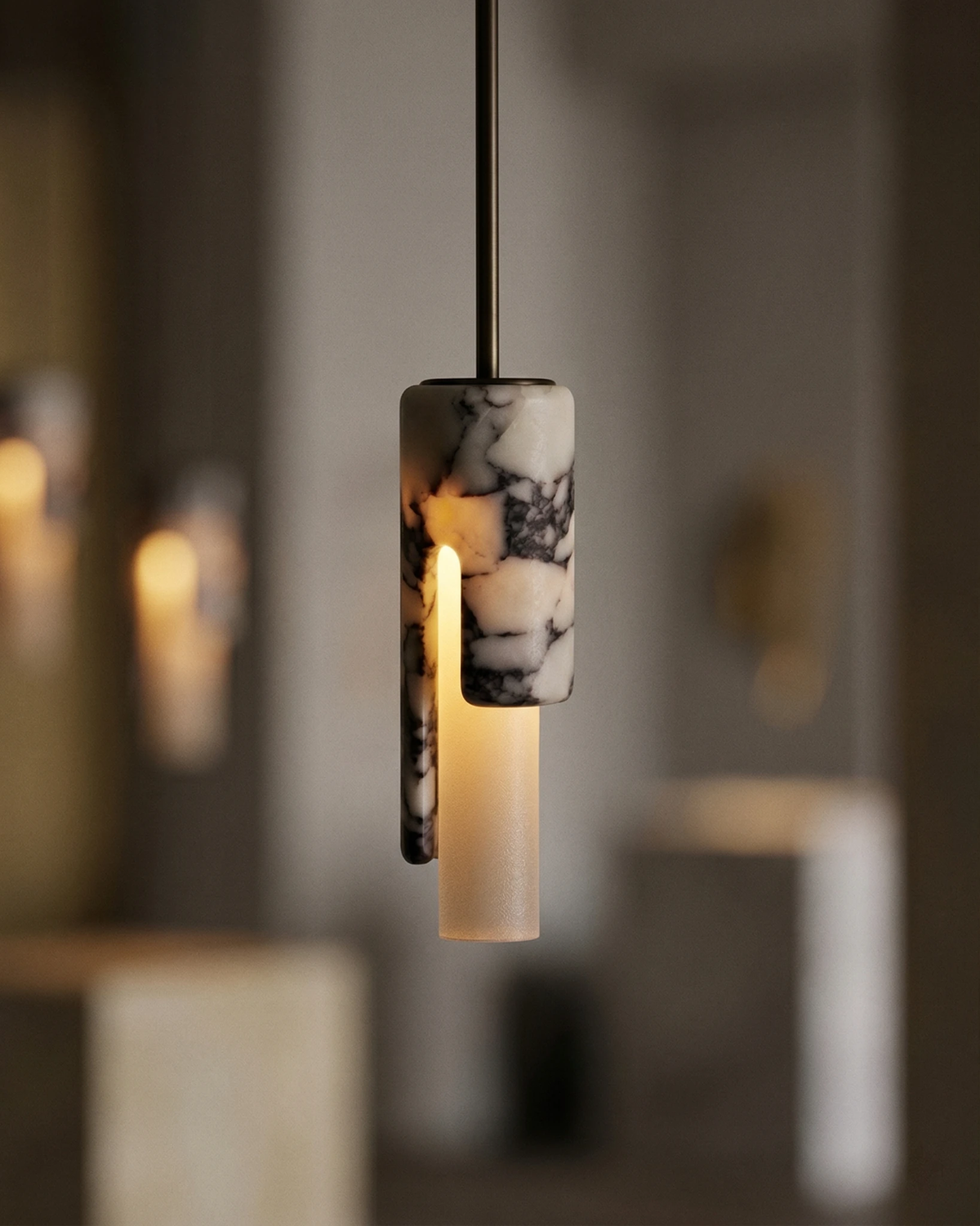 Marble pendant light PALERMO No.01 lit, veined cylinder with a vertical cutaway glowing in a softly blurred interior