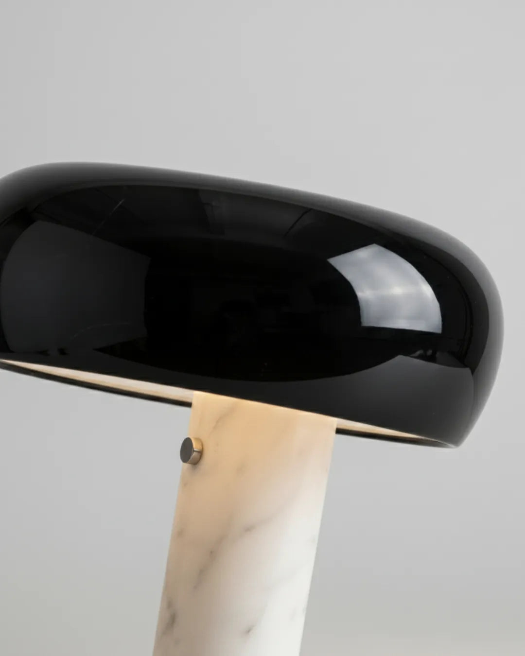 Close-up of the marble table lamp BRUNO No.01, glossy black enamel shade edge and veined white marble stem with screw