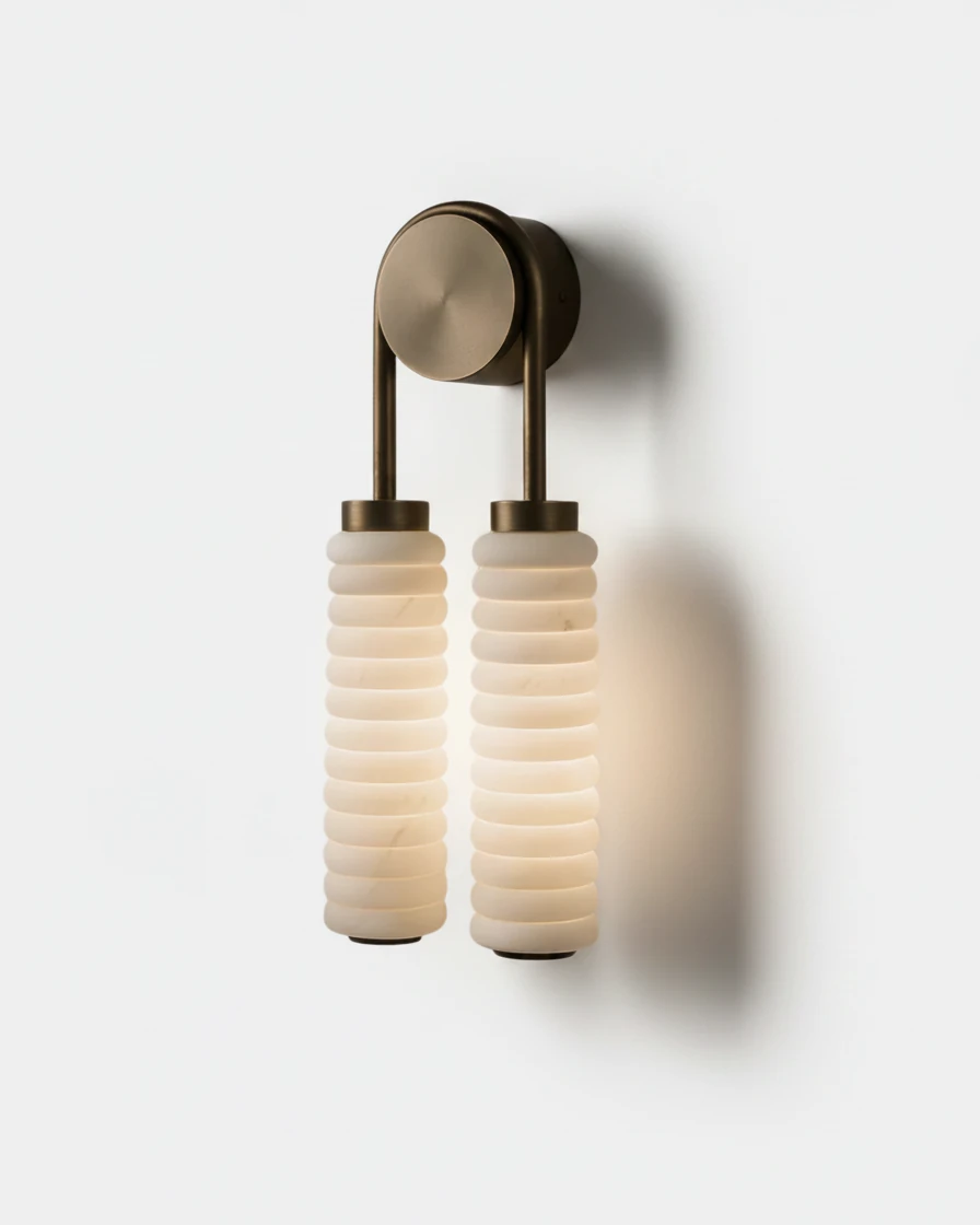 Marble vanity light TORRE No.02, twin stacked marble columns lit under a round brass bracket on a plain background