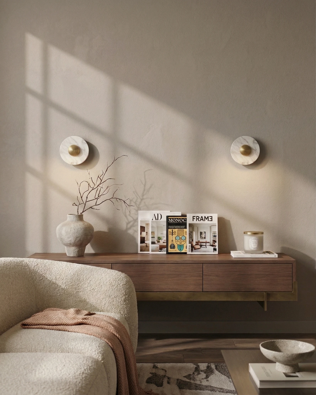 Marble wall sconce LATTE No.01, a pair with brass centers glowing softly above a walnut floating credenza