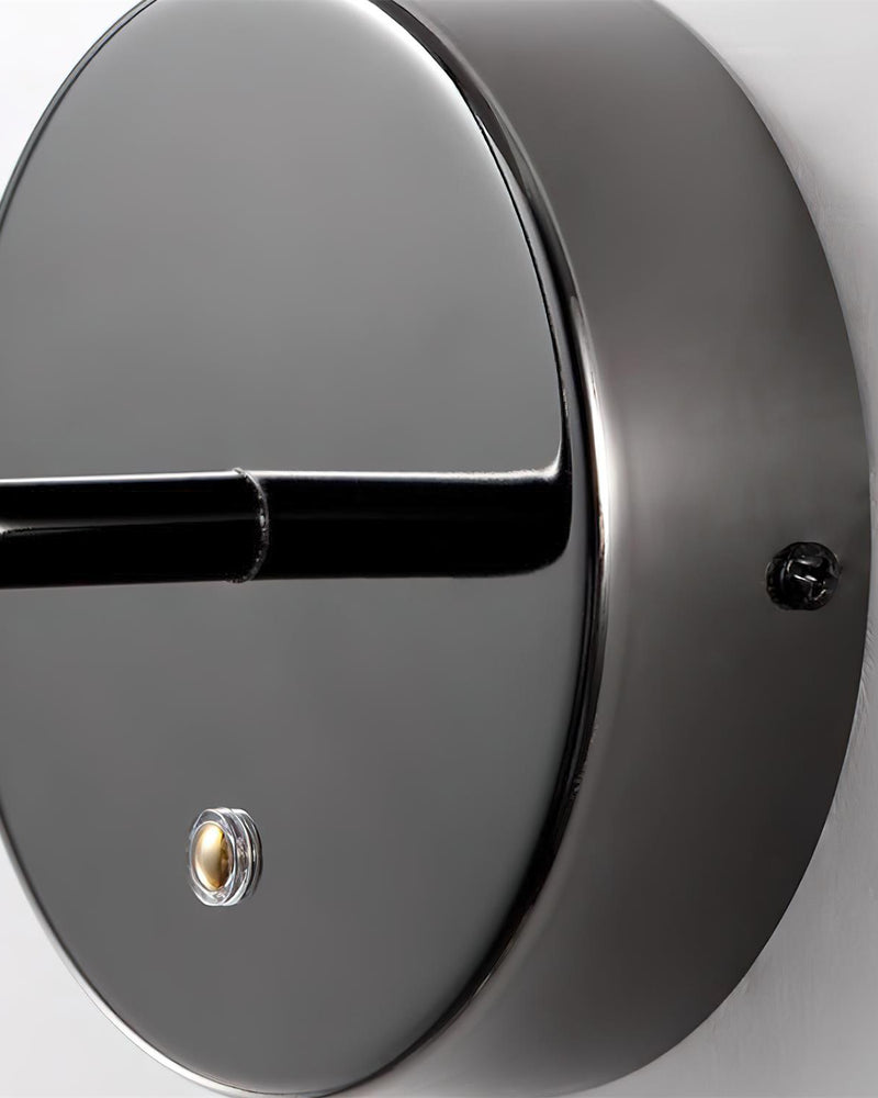 Close-up of the polished gunmetal round backplate, arm and switch of the marble wall sconce NUVOLA No.01