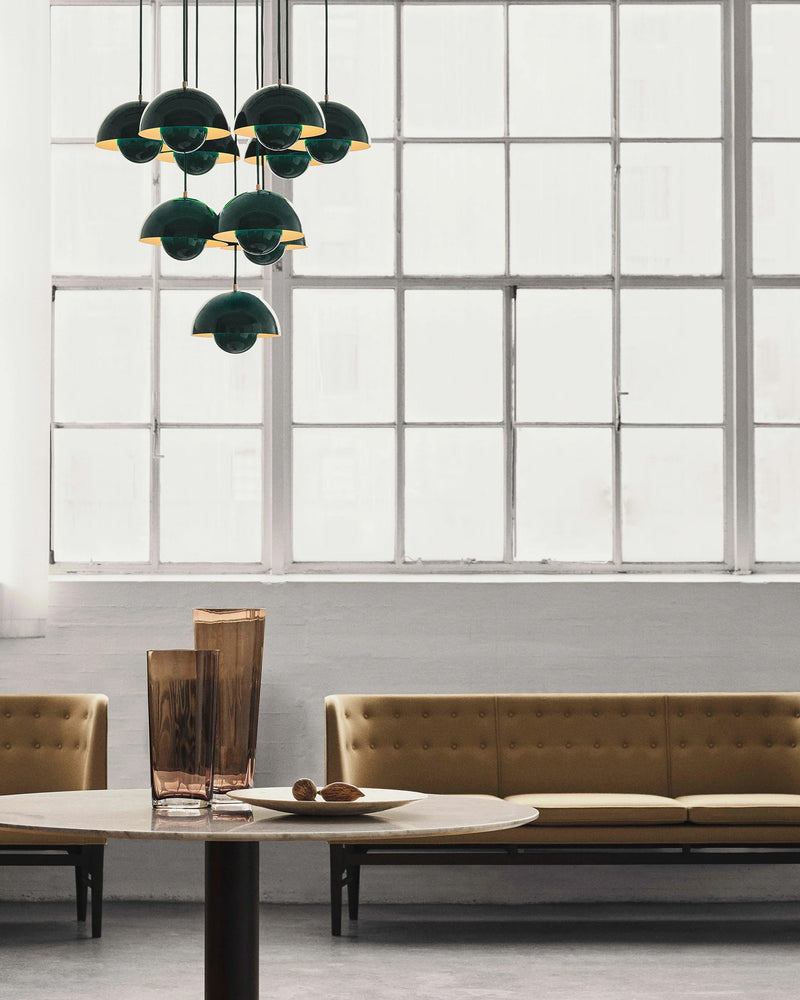 Modern chandelier FLORA No.01 in forest green hanging by a large steel window above a lounge sofa and low table