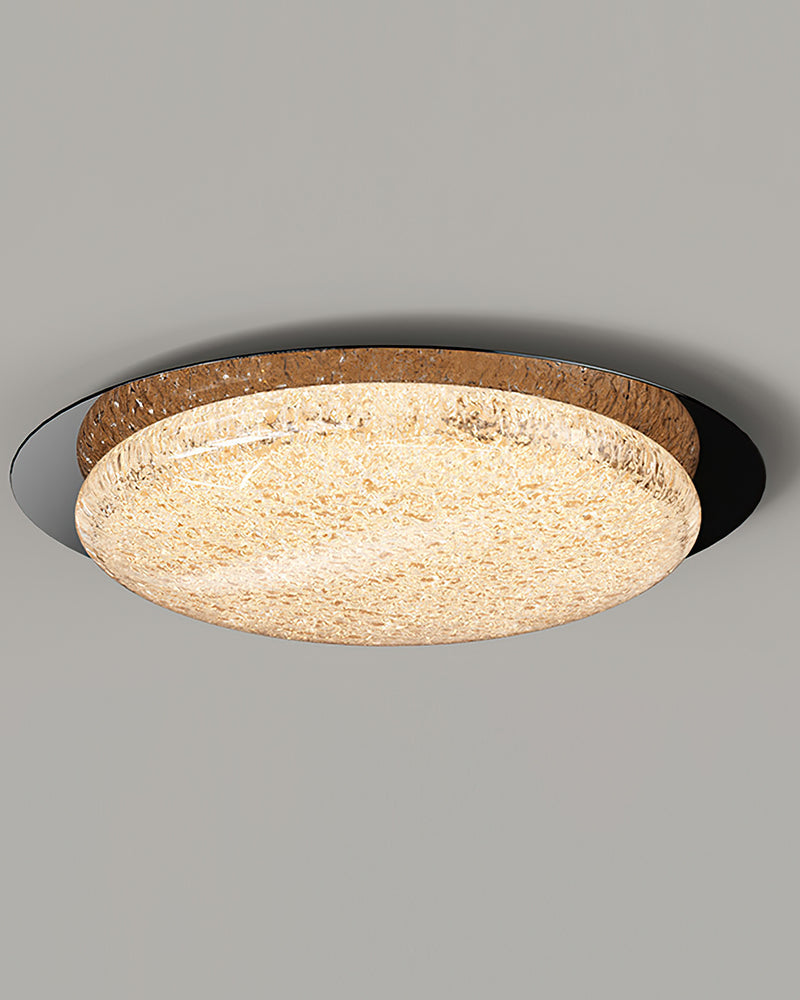 Modern flush mount ceiling light NIVE No.01 in Matte Black at an angle, glowing textured disc on a gray ceiling