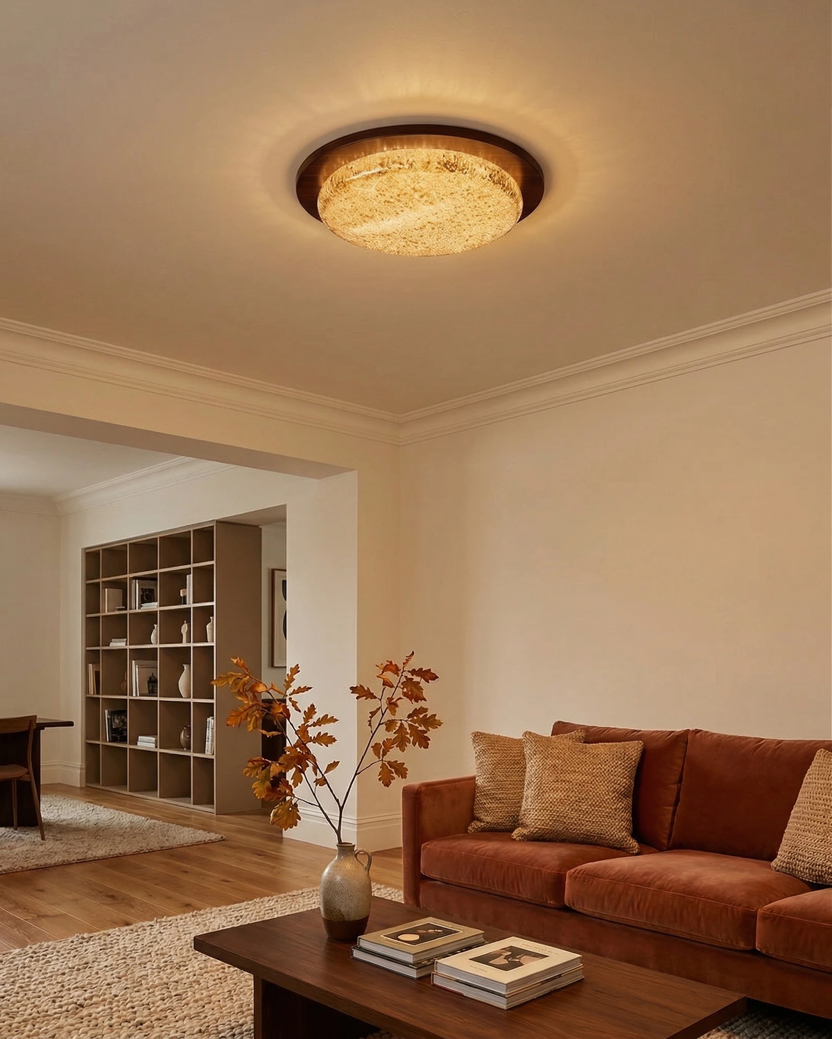 Modern flush mount ceiling light NIVE No.01 switched on above a rust velvet sofa and a walnut coffee table