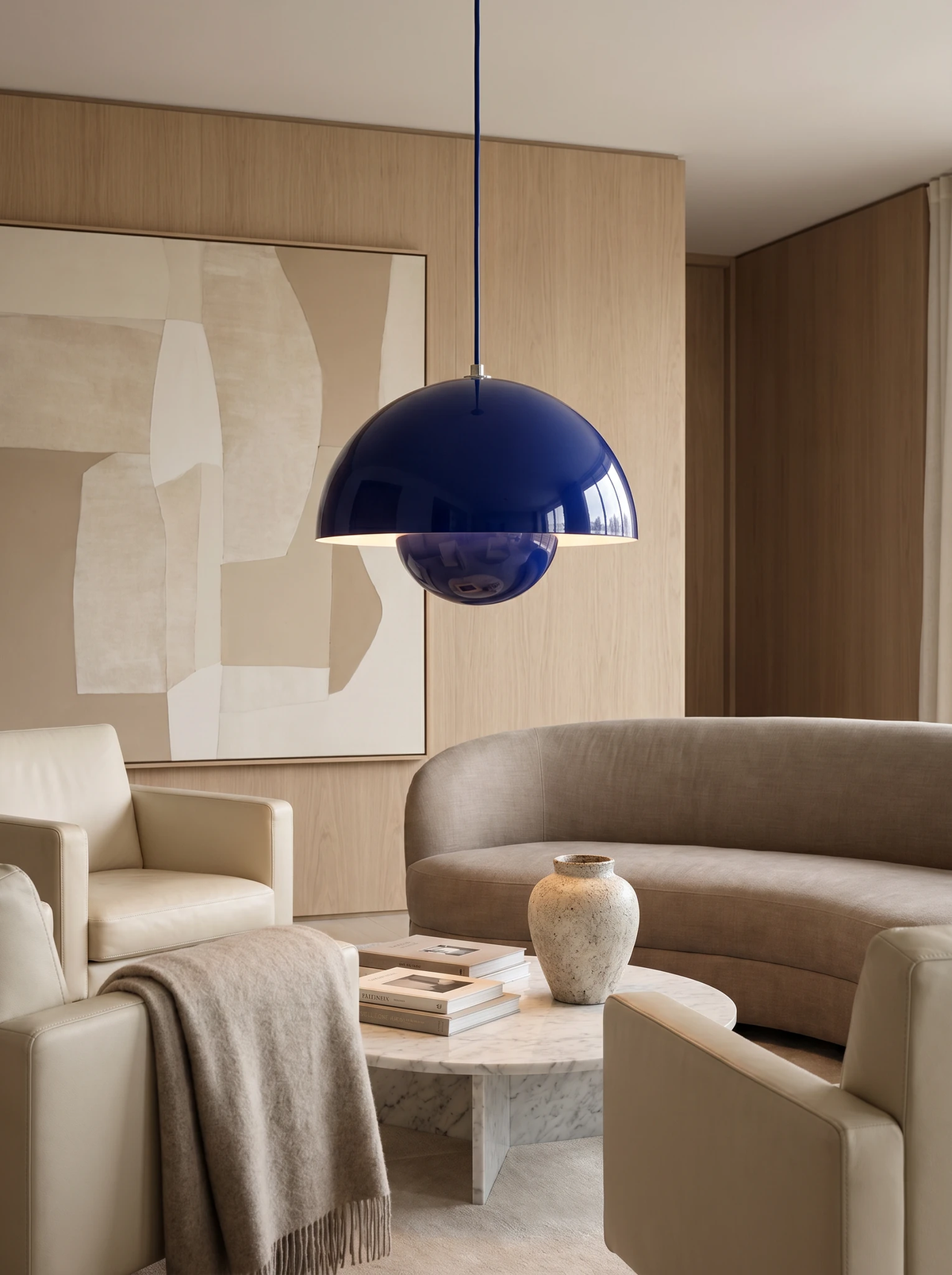 Modern pendant light ALTO No.01 in cobalt blue lacquer hanging in a living room above a beige sofa