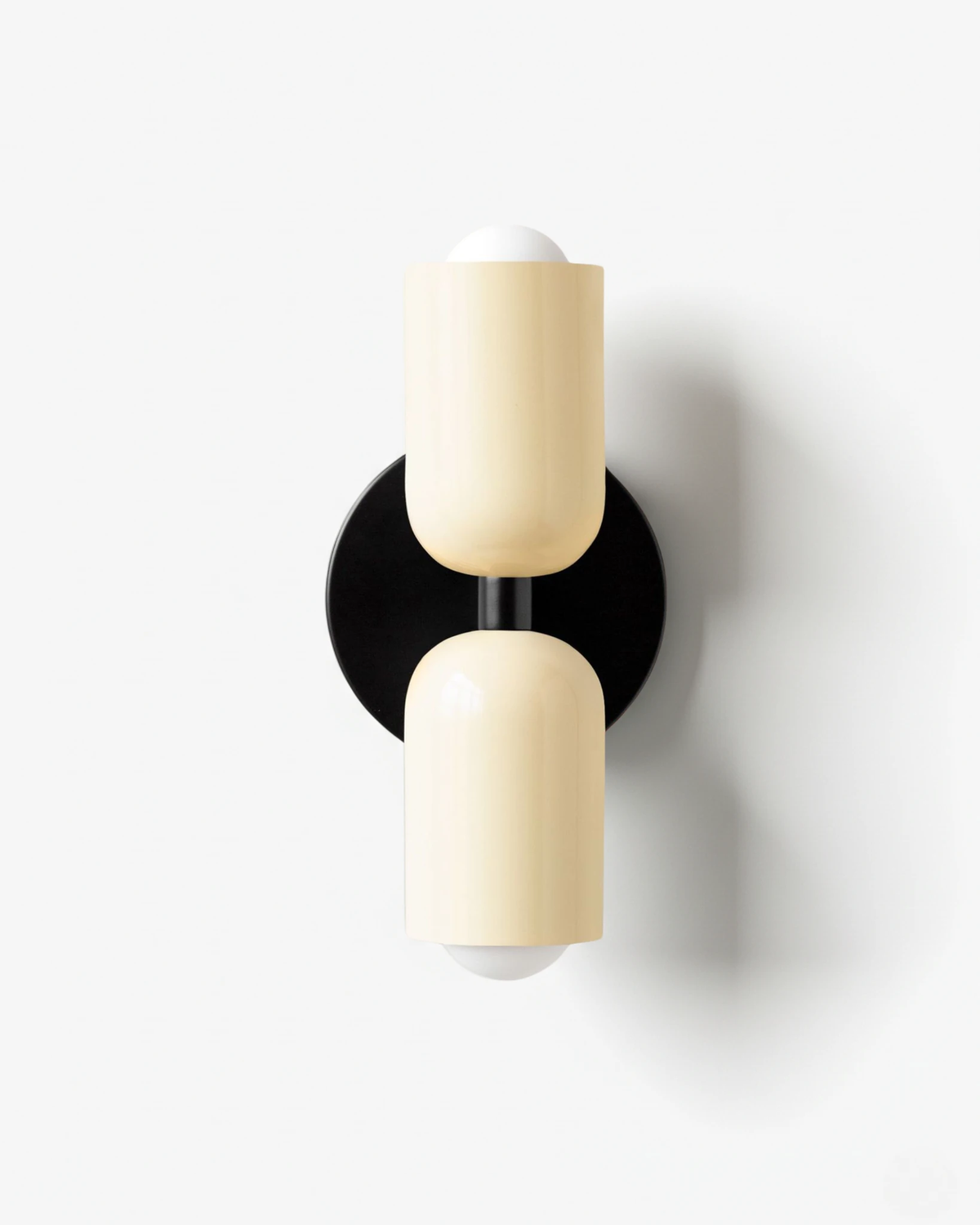 Modern wall sconce TORINO No.01 in Beige & Beige, two cream glossy capsules stacked on a black backplate, unlit