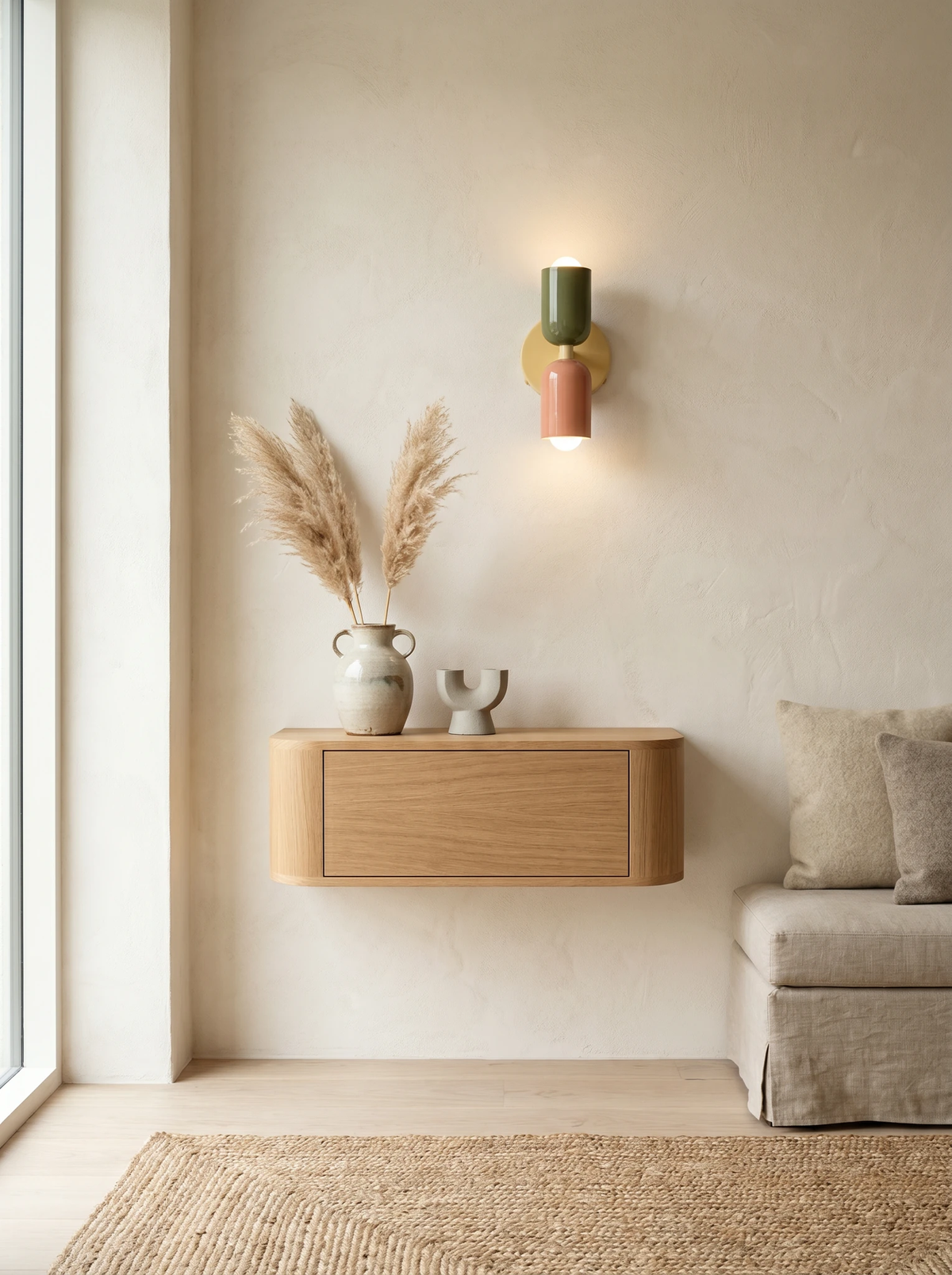 Modern wall sconce MURO No.02 in sage and pink, switched on above a floating oak cabinet with pampas grass