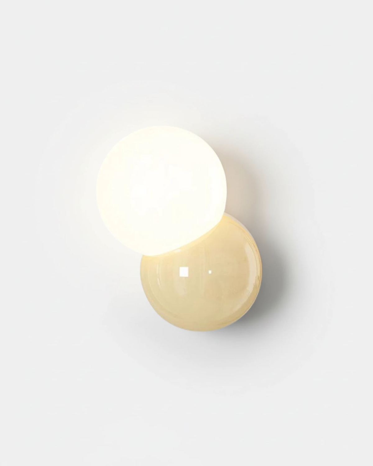 Modern wall sconce AURA No.01 in light yellow, glowing white globe over a pale yellow sphere