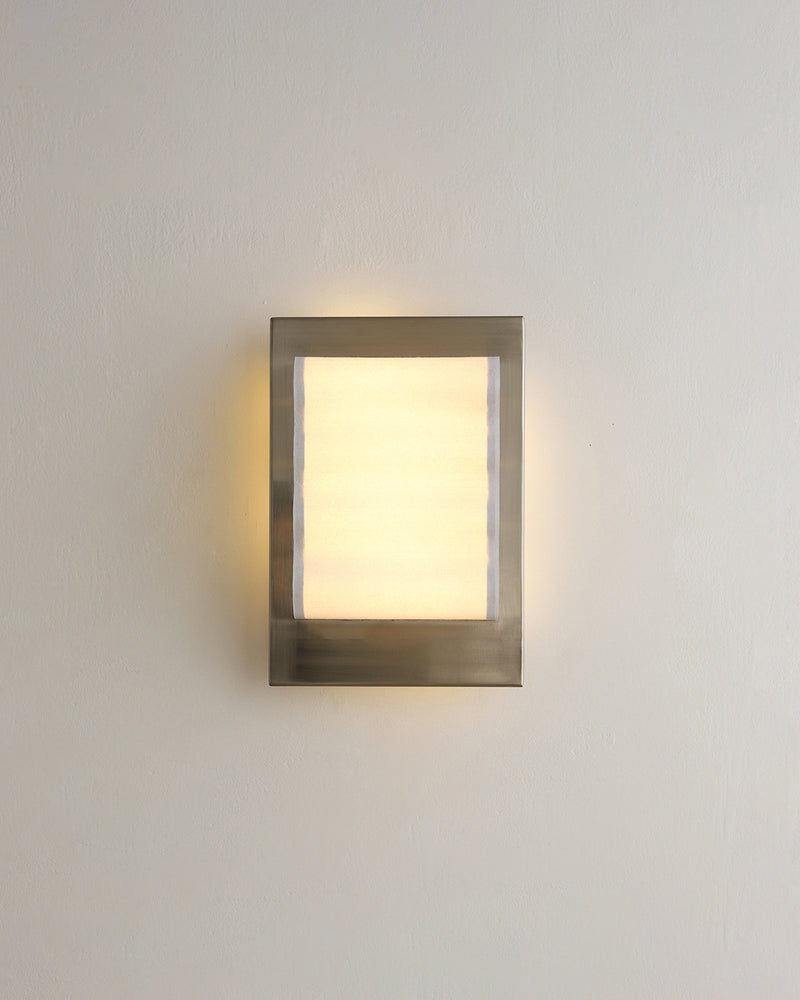 Modern wall sconce MILANO No.01 seen straight on, flat lit acrylic panel framed in brushed chrome