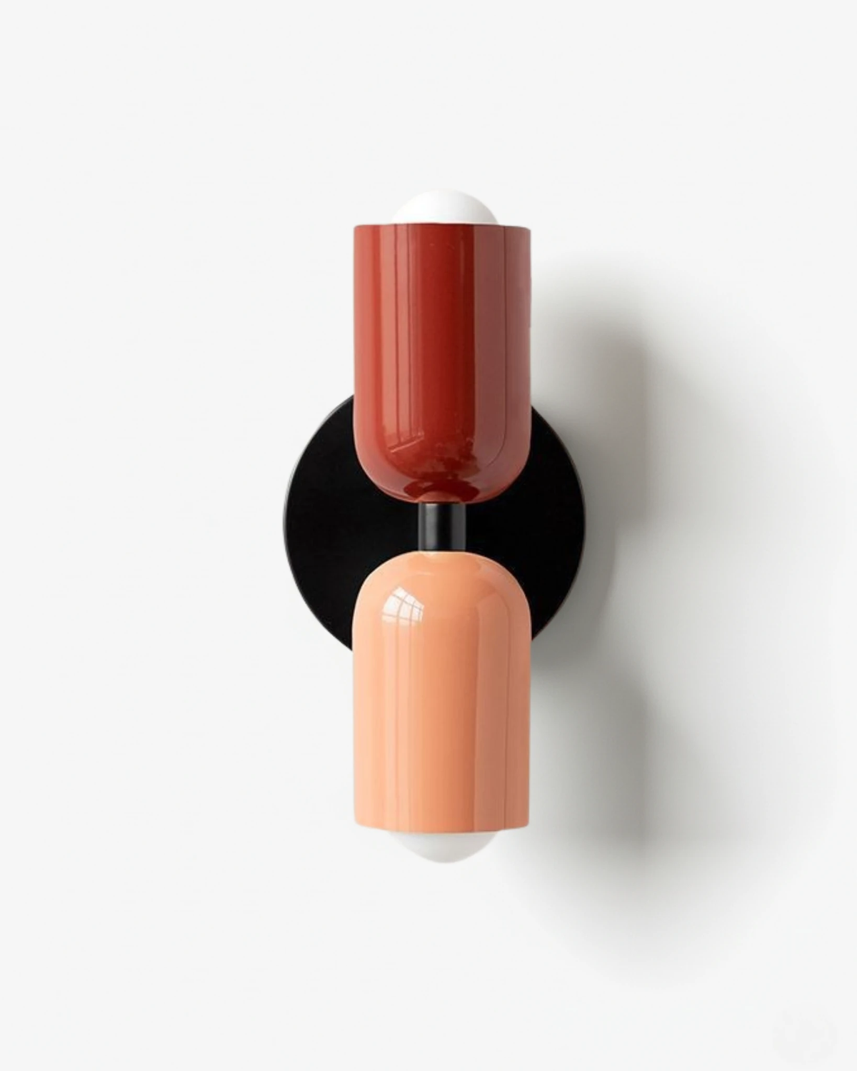 Modern wall sconce TORINO No.01 in Red & Pink, red upper capsule and pink lower capsule on a black round backplate