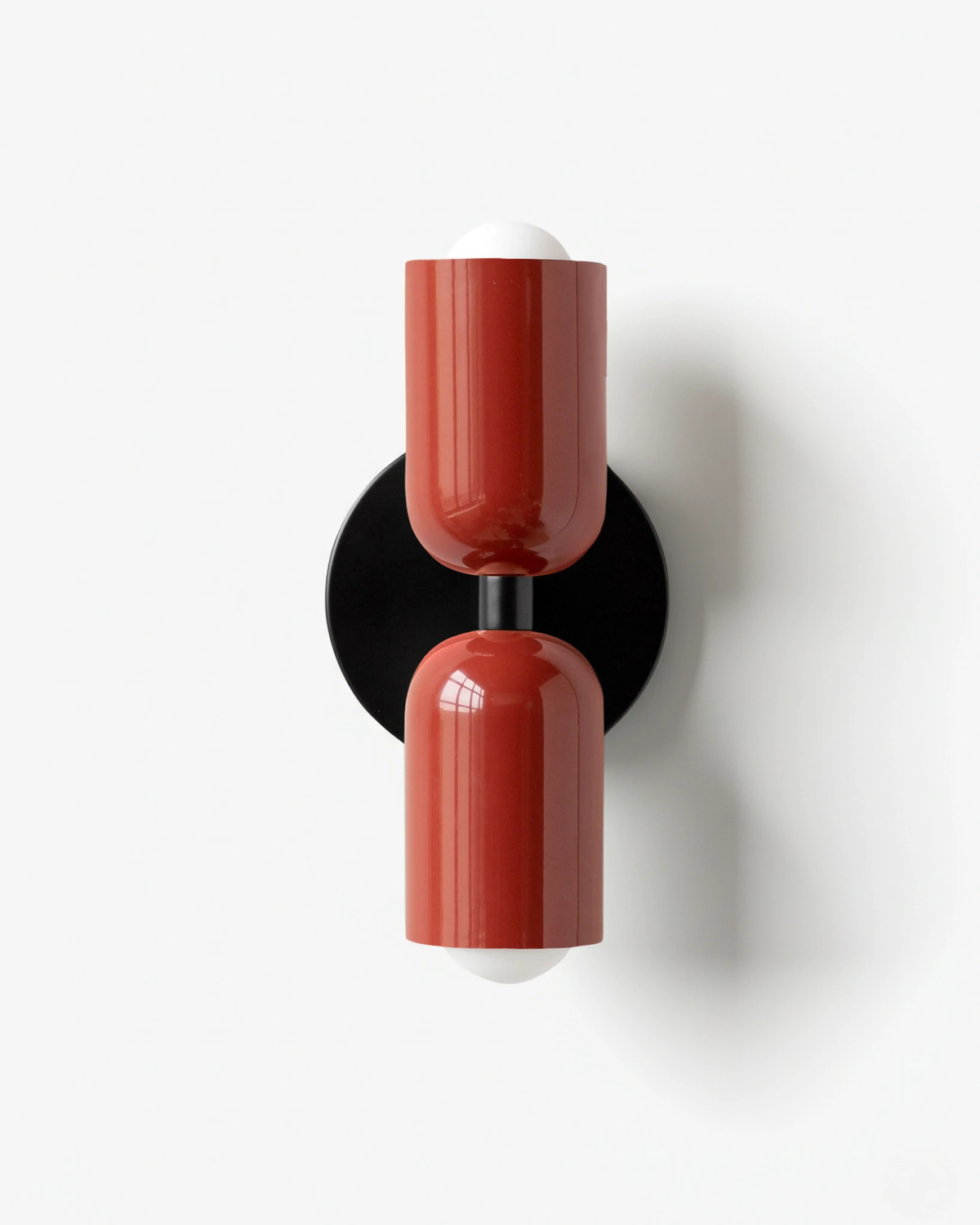 Modern wall sconce TORINO No.01 in Red & Red, matching oxblood capsules up and down on a black iron mount