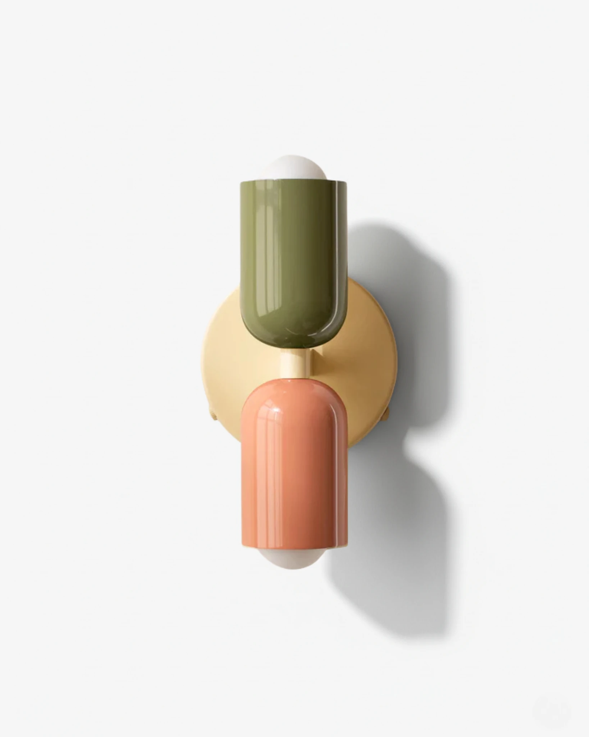 Modern wall sconce MURO No.02 in Sage & Powder Pink, green upper and pink lower capsule on a round brass backplate