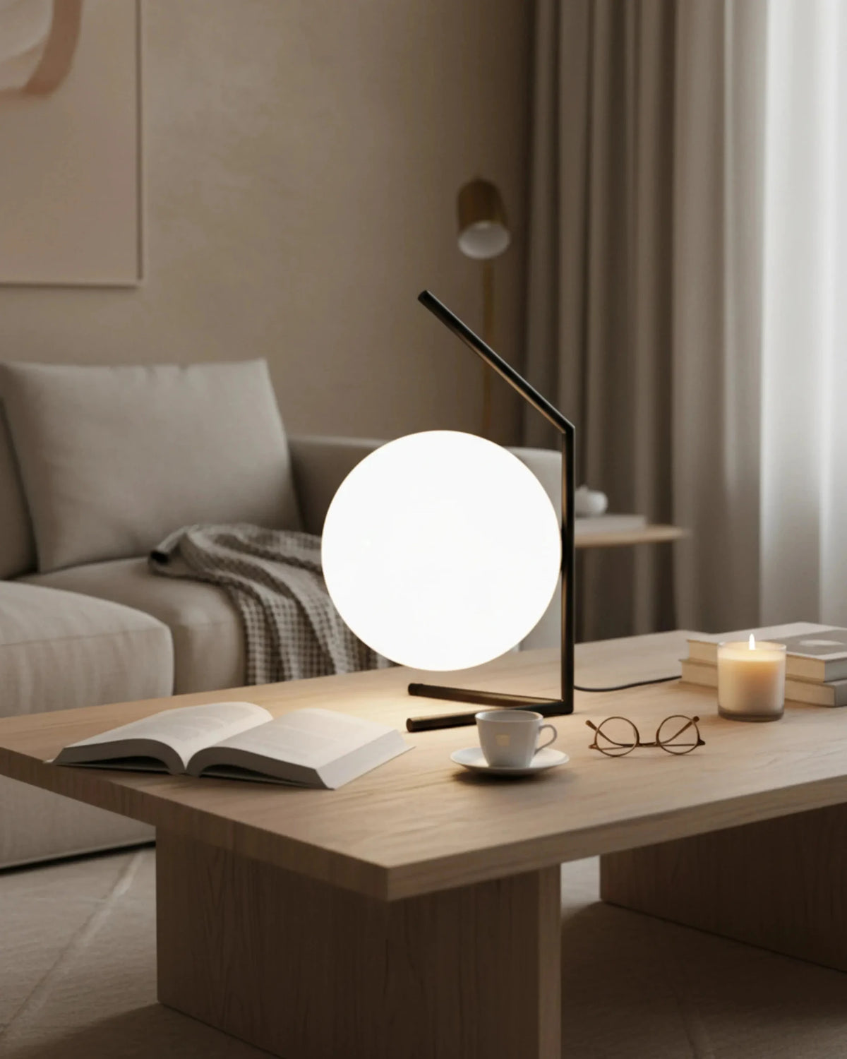 Opal globe table lamp ENNA No.01 switched on atop a wooden coffee table with an open book, glasses and a candle