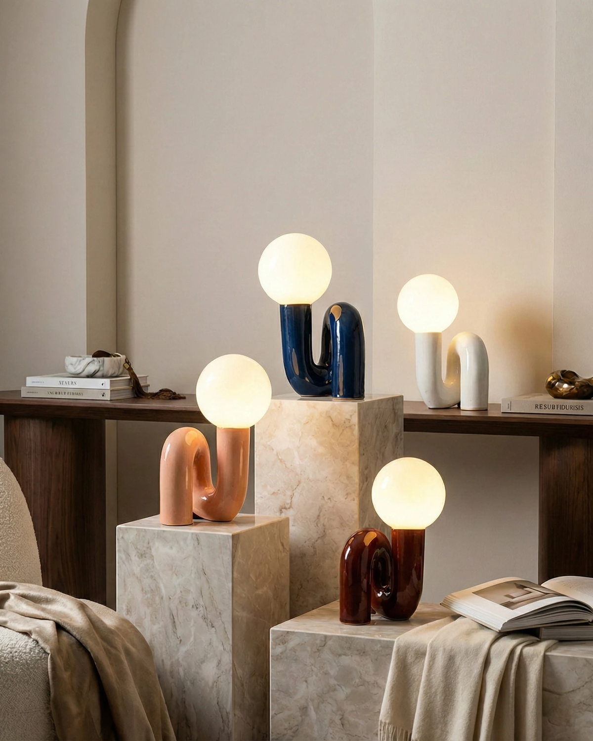 Four opal globe table lamps VICO No.01 in blue, rose, off-white and red lit on stone plinths