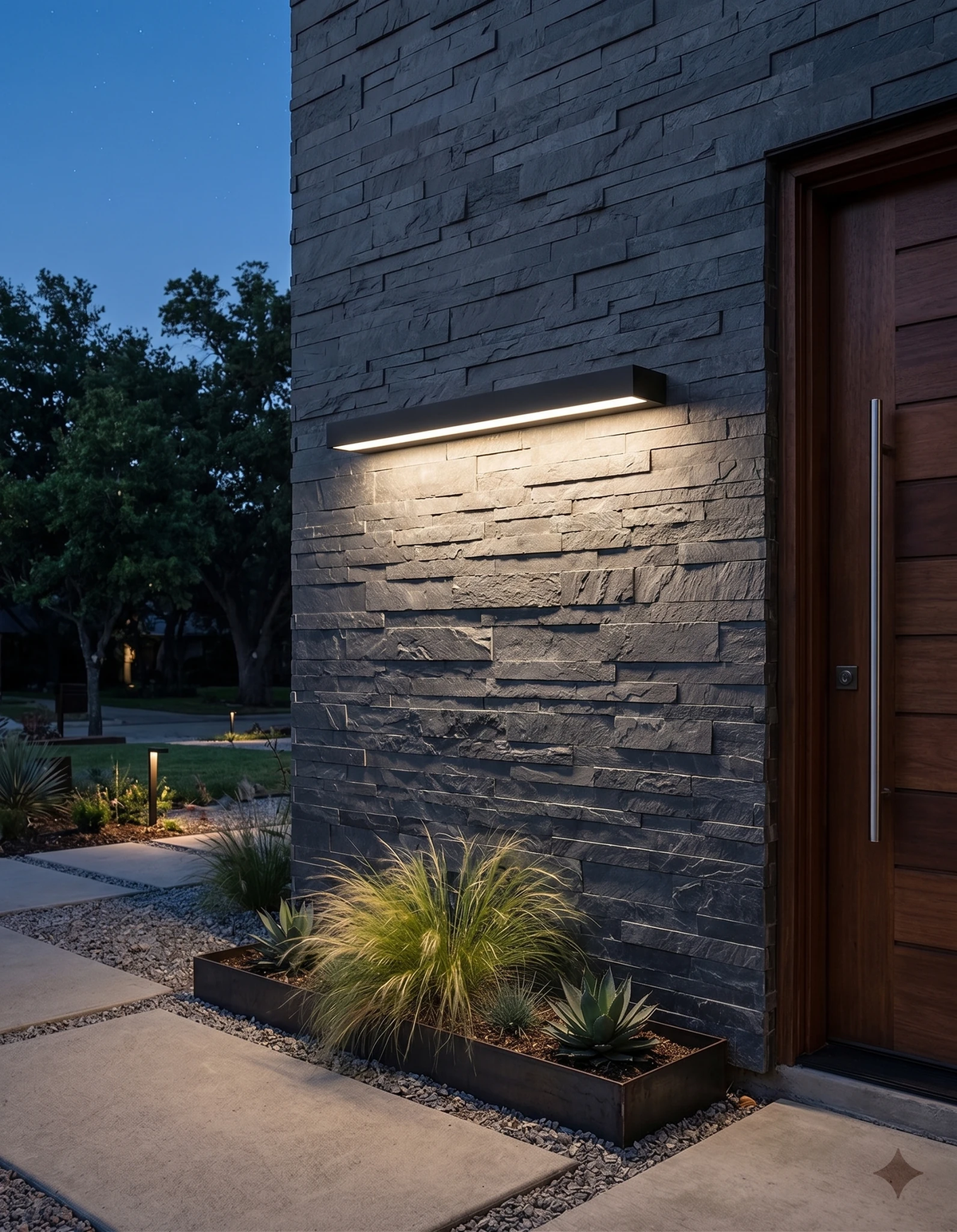 Outdoor wall sconce FORTE No.01 in matte black lit on a slate wall beside a wood front door at dusk
