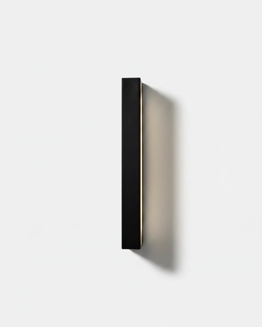 Outdoor wall sconce FRECCIA No.01 in the 100 cm (39.4 in) size, slim matte black bar switched on with a warm side glow