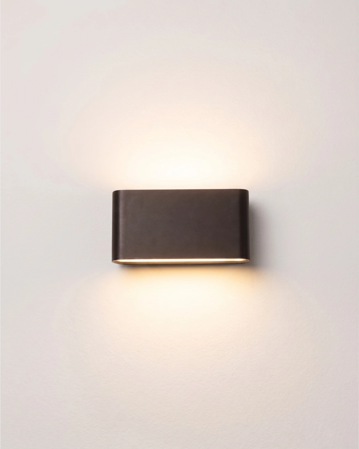 Outdoor wall sconce PISA No.01 medium size in deep black, switched on with warm up and down light