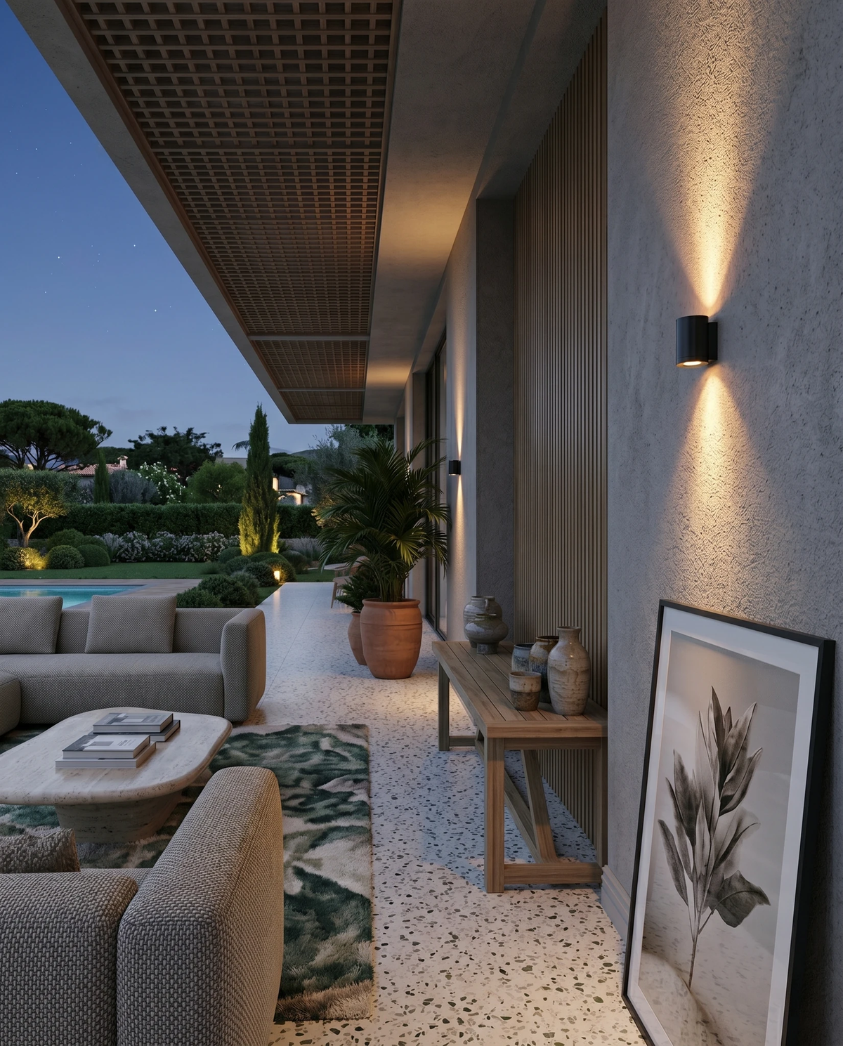 Outdoor wall sconce PALAZZO No.01 in matte black, lit on the wall of a covered patio lounge with sofas at dusk