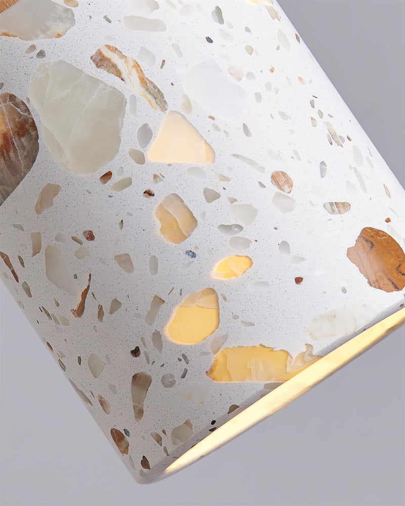 Close-up of the GROTTA No.01 terrazzo pendant light cylinder, gold-flecked terrazzo glowing when lit
